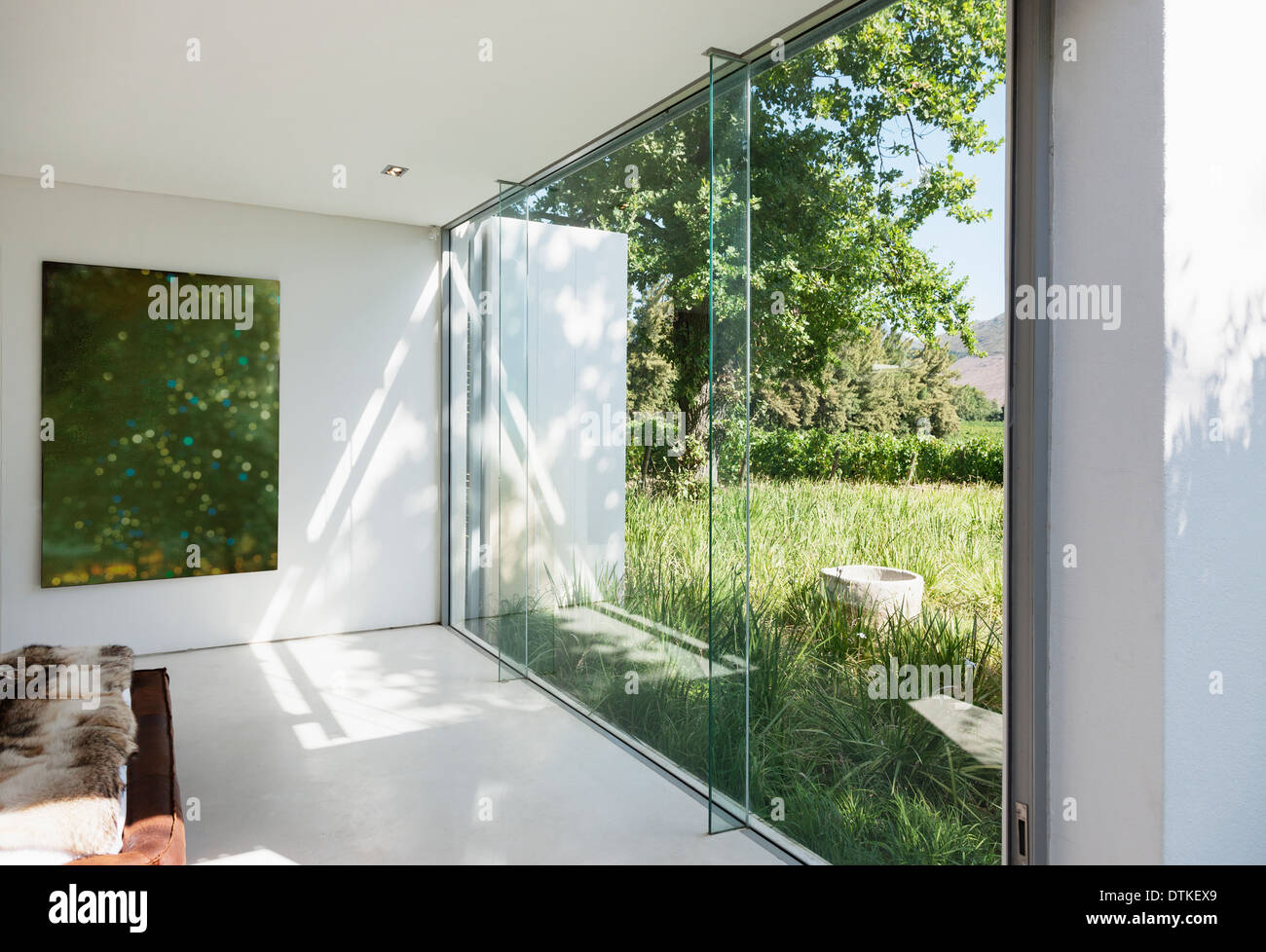 Modernes Haus mit Glaswänden mit Blick auf Rasen Stockfoto