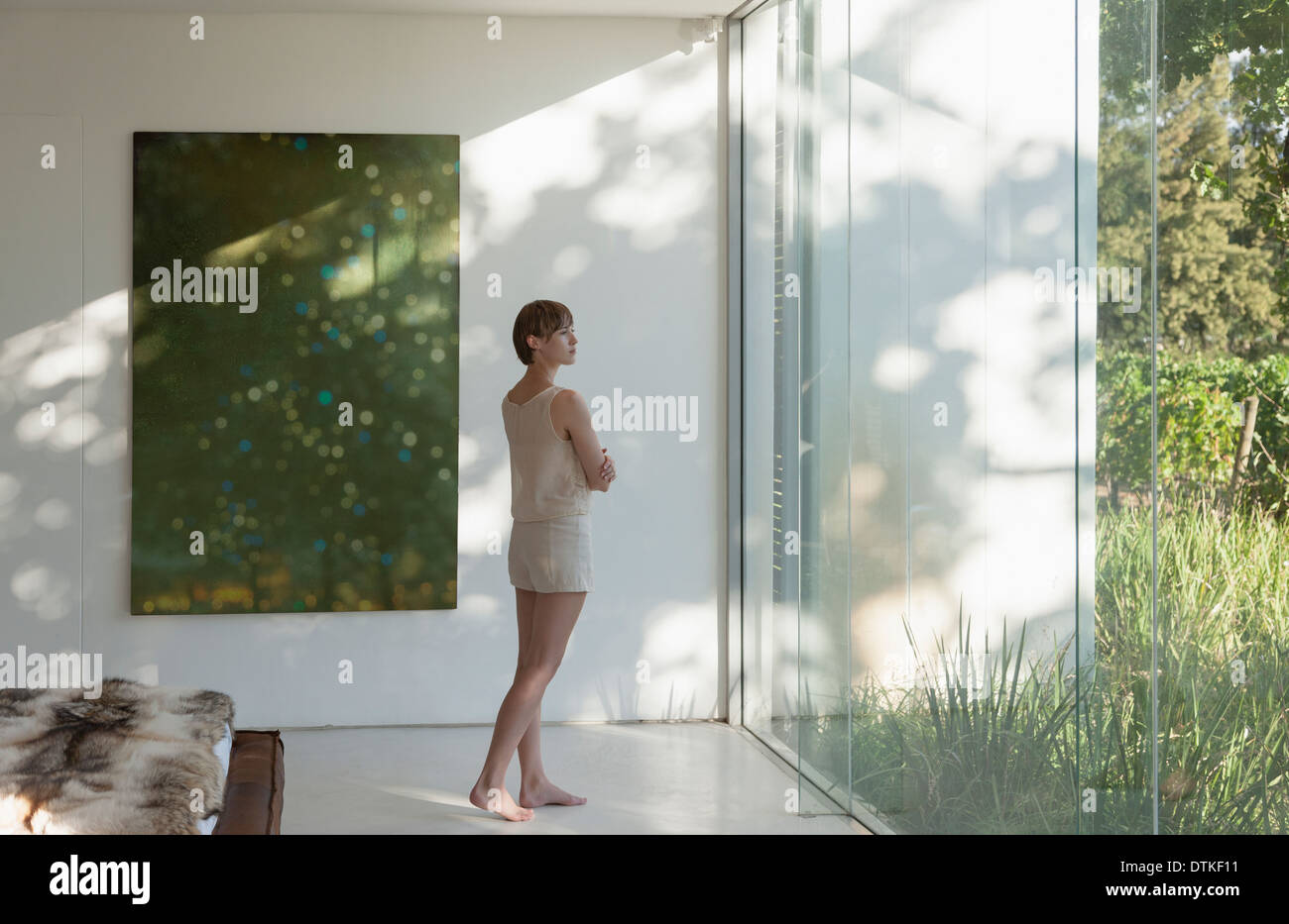 Frau am Fenster in modernen Schlafzimmer Stockfoto