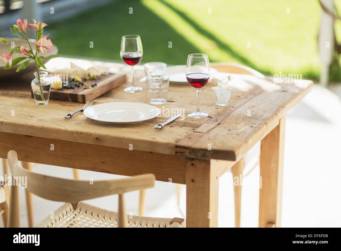 Wein und Aperitif auf hölzernen Esstisch auf der Terrasse Stockfoto