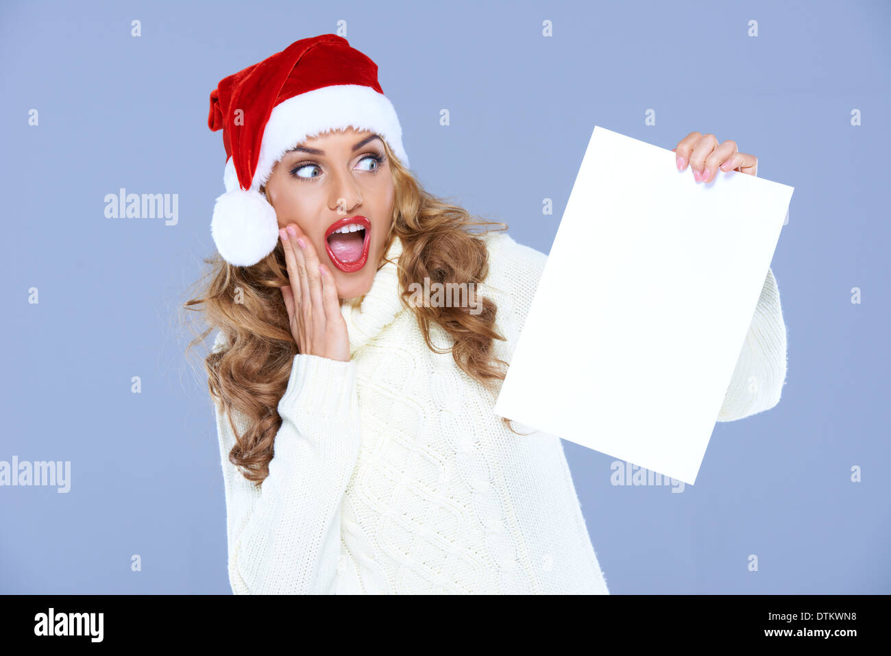 Blonde Frau in Weihnachtsmütze ist Hudge geschockt Stockfoto