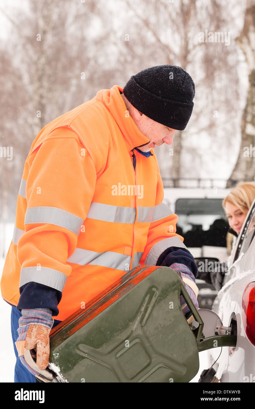 Mann Frau Auto Gas Winter Hilfe ausfüllen Stockfoto
