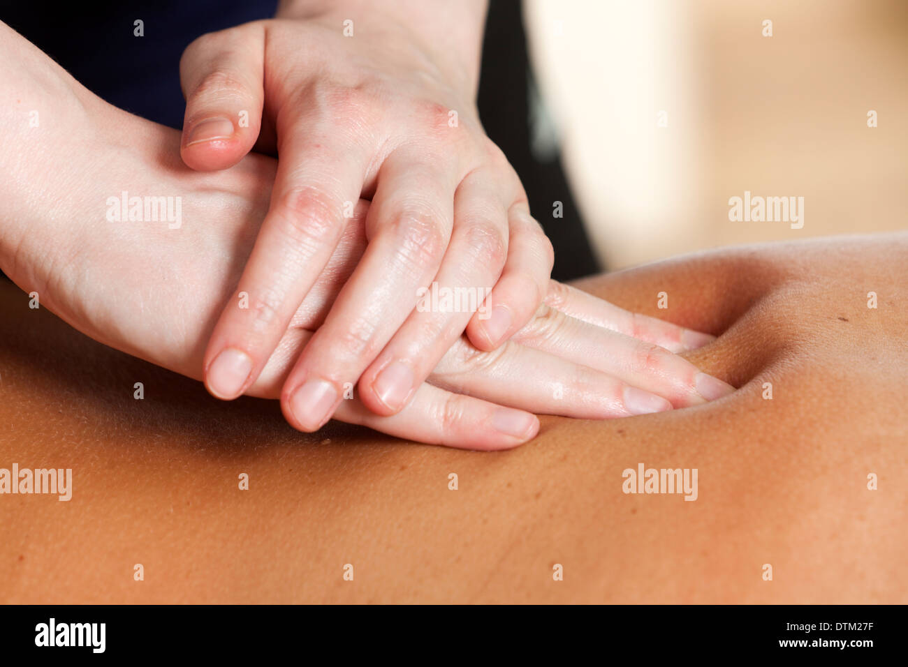 Rücken Sie-Massage. Nahaufnahme der Hände des weiblichen Masseur drücken eine Frau zurück Stockfoto