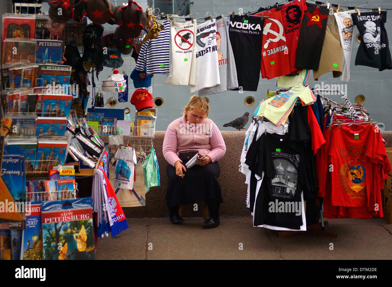 Gelangweilt auf der Suche Geschenk Shop Street Hersteller, Rauchen und lesen ein Buch. in St. Petersburg, Russland Stockfoto