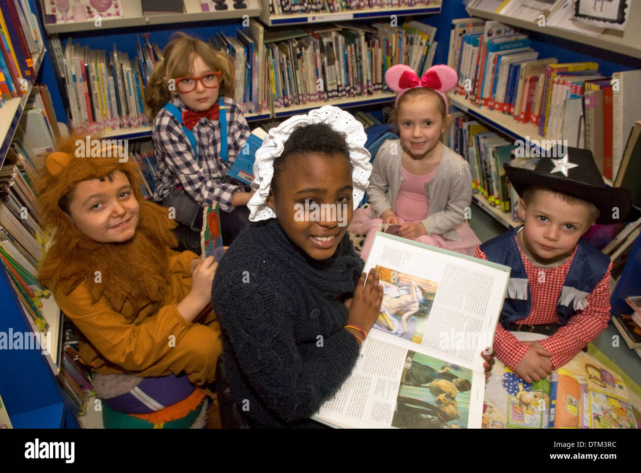 Grundschüler als lieblingsbuch Zeichen in der Schule, Bibliothek, Haslemere, Surrey, UK gekleidet. Stockfoto