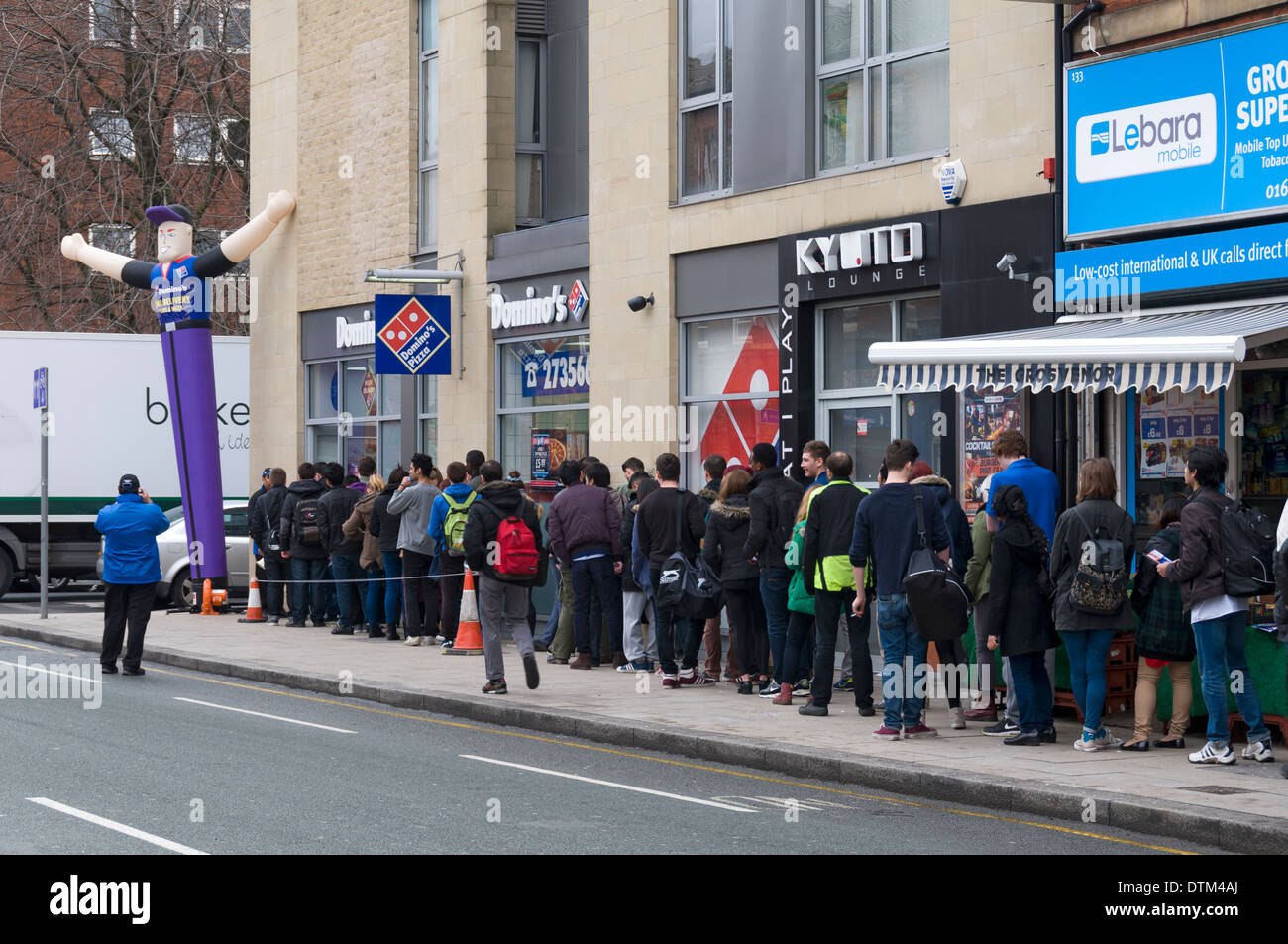 Eine Warteschlange vor einem Domino Pizza Shop, Grosvenor Street, Manchester, UK. Stockfoto