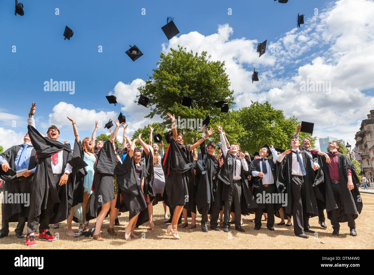 Absolventinnen und Absolventen feiern ihren Abschluss durch das werfen ihre Mörtel-Boards in der Luft am College Green, Bristol. Stockfoto