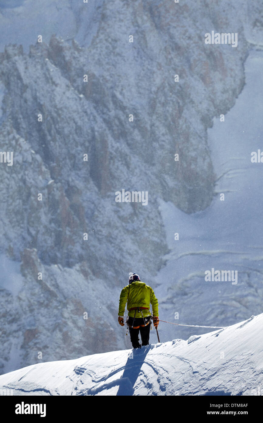 Einsamer Kletterer über einen Grat unterhalb Mont Blanc, hoch über dem Tal von Chamonix in den französischen Alpen. Stockfoto