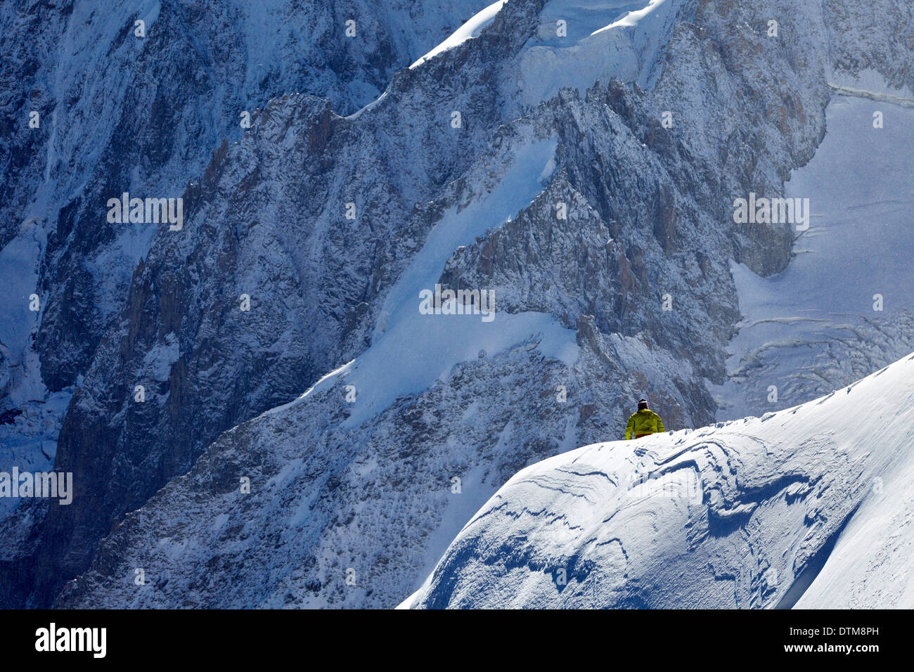 Einsamer Kletterer über einen Grat unterhalb Mont Blanc, hoch über dem Tal von Chamonix in den französischen Alpen. Stockfoto