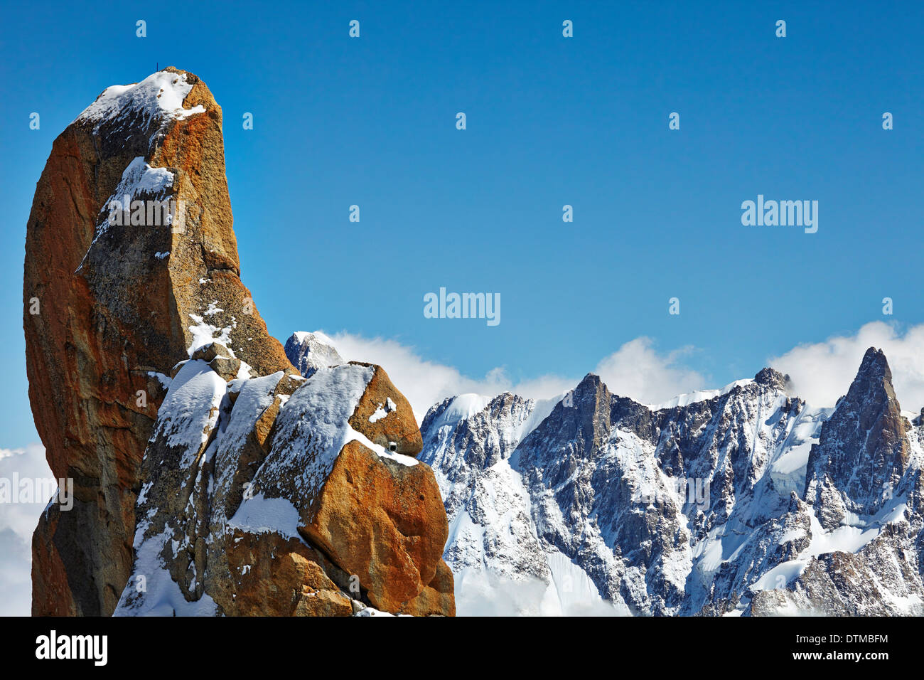 Große, rote Felsen auf dem Gipfel der Aiguille du Midi in den französischen Alpen über dem Tal von Chamonix. Stockfoto