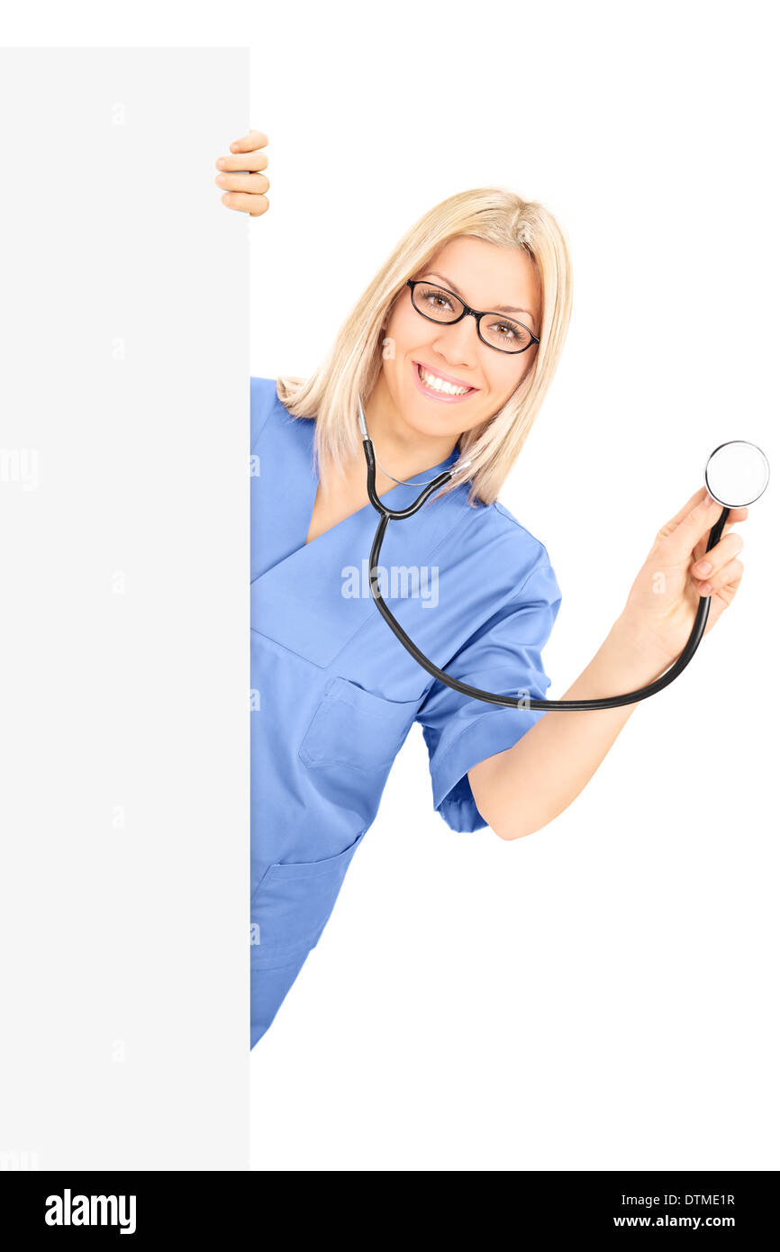 Junge Ärztin mit Stethoskop posiert hinter Blindplatte Stockfoto