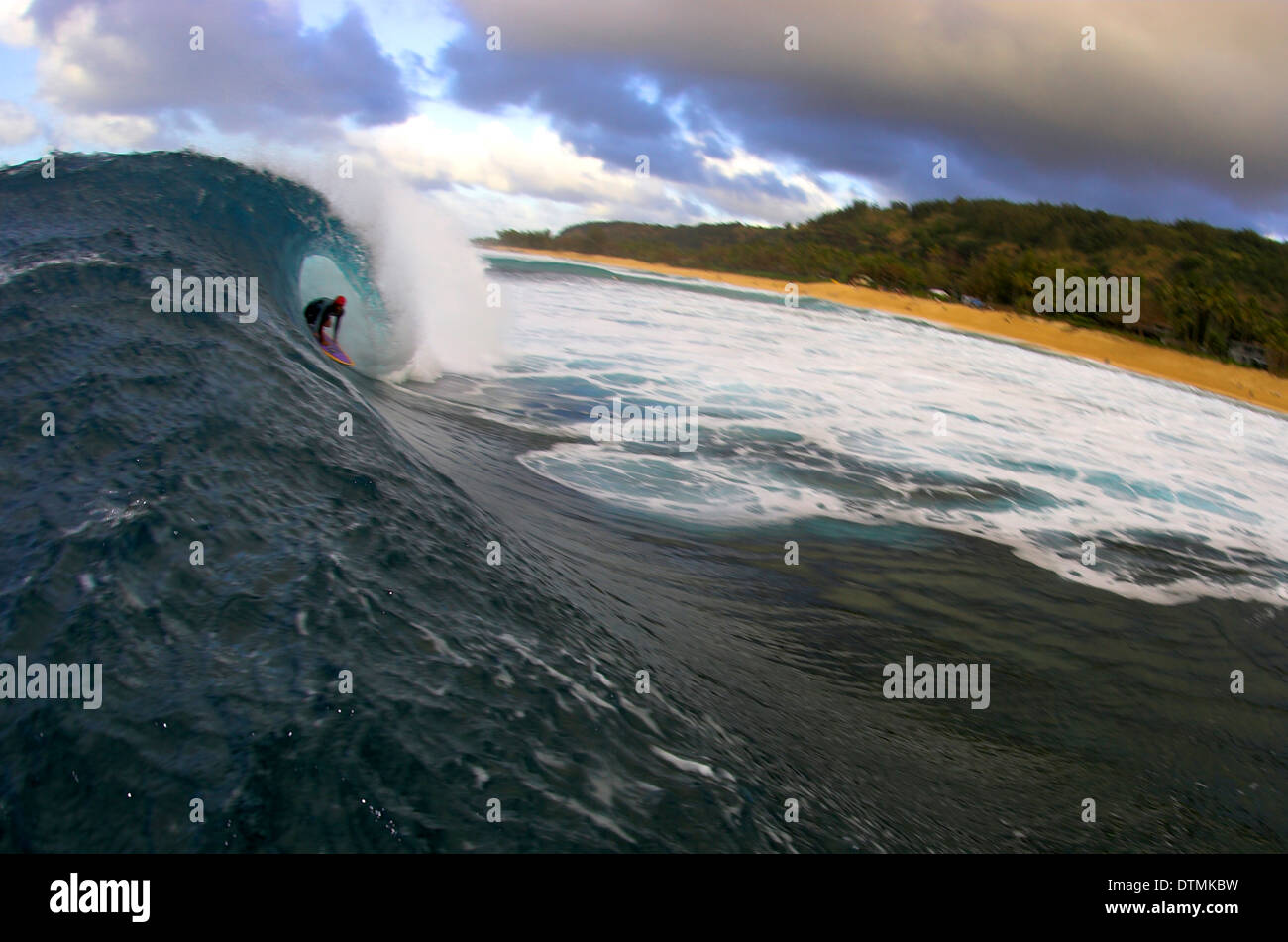 Surfer, die immer in einer Welle im Ozeanstrand barreled Stockfoto