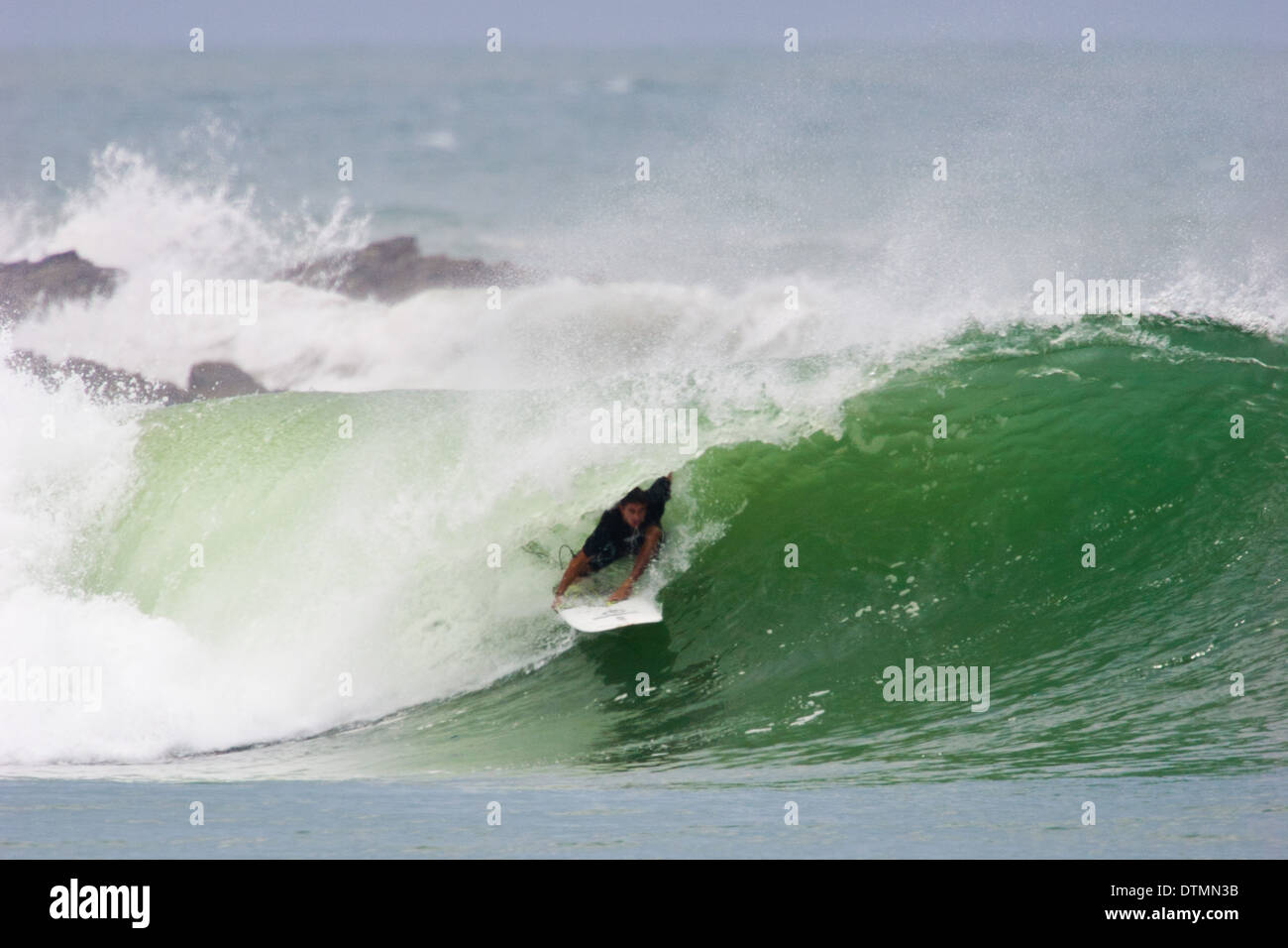 Surfer, die immer von einer Welle barreled Stockfoto