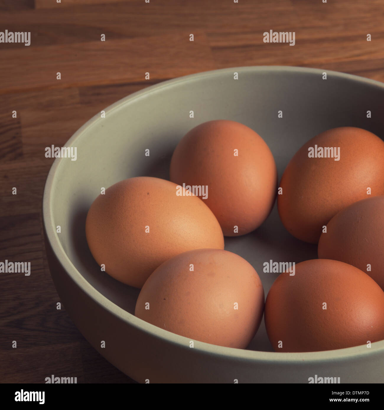 Sechs kostenlose Bereich Eiern in eine Schüssel geben, eine Eiche Küche obenauf. Stockfoto