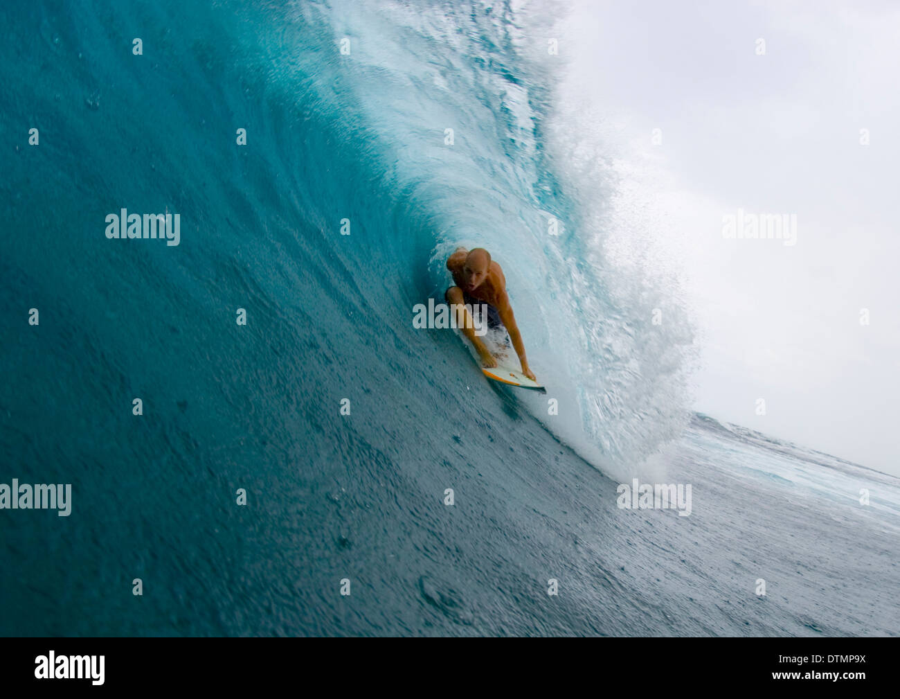 Surfer auf einem Surfbrett auf einer Welle im Ozean Meer Wasser Welle Strand spiegeln und dabei Tricks in einem Neoprenanzug und boardshorts Stockfoto