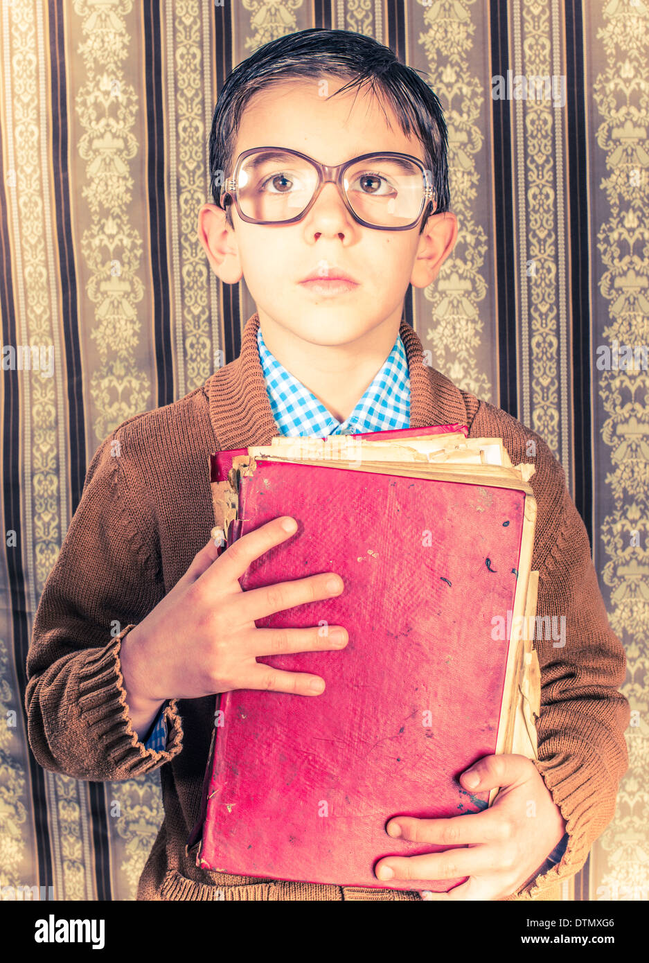 Kind mit Brille halten rote Vintage Buches. Vintage-Kleidung Stockfoto