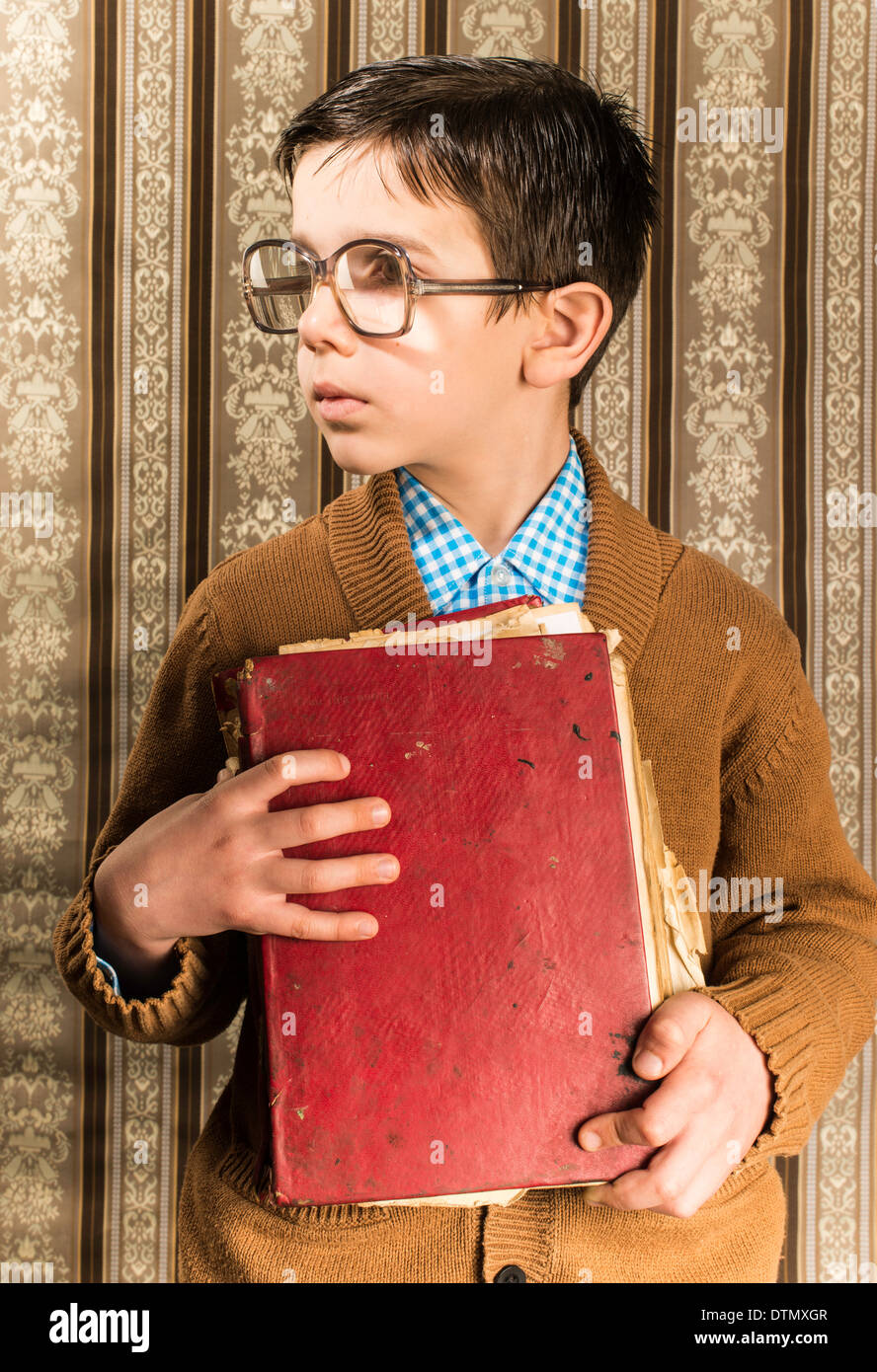 Kind mit Brille halten rote Vintage Buches. Vintage-Kleidung Stockfoto