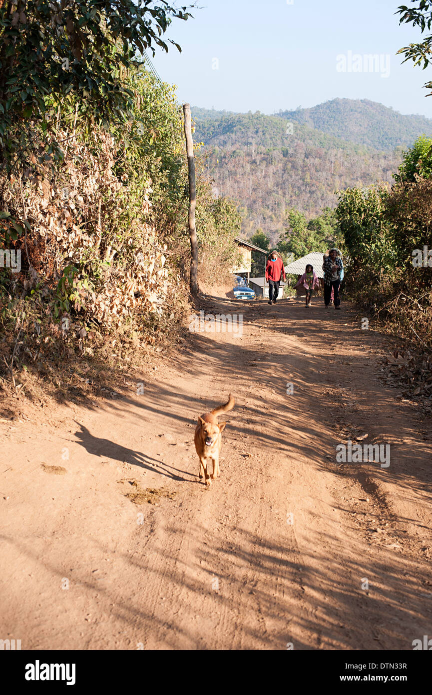 Familie gehen eines hügeligen Dorfstraßen in Huay Pakoot, Nord-Thailand. Stockfoto