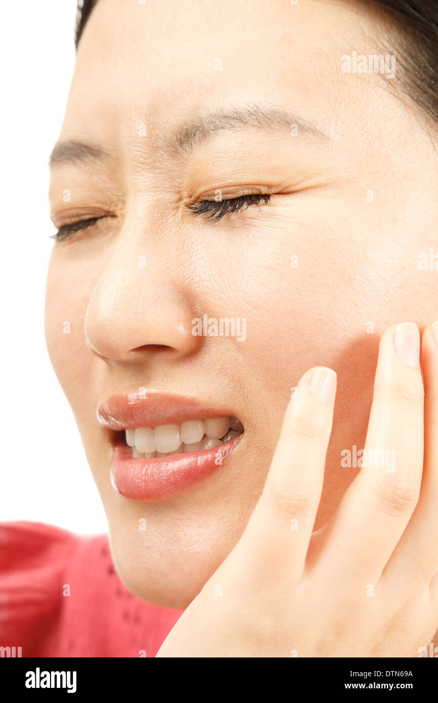 Junge Asiatin mit Zahnschmerzen auf weißem Hintergrund Stockfoto