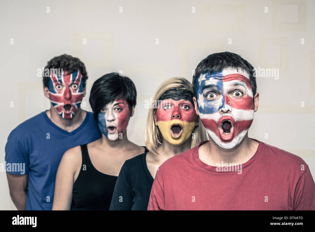 Gruppe von überrascht die Menschen mit bemalten Fahnen auf ihren Gesichtern. Stockfoto