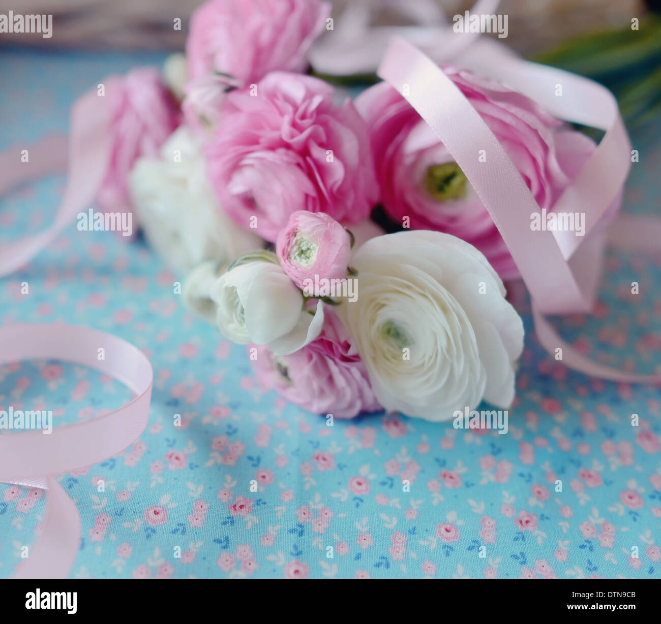 auf blauem Grund ist ein feines Bukett von Butterblumen mit Band Stockfoto