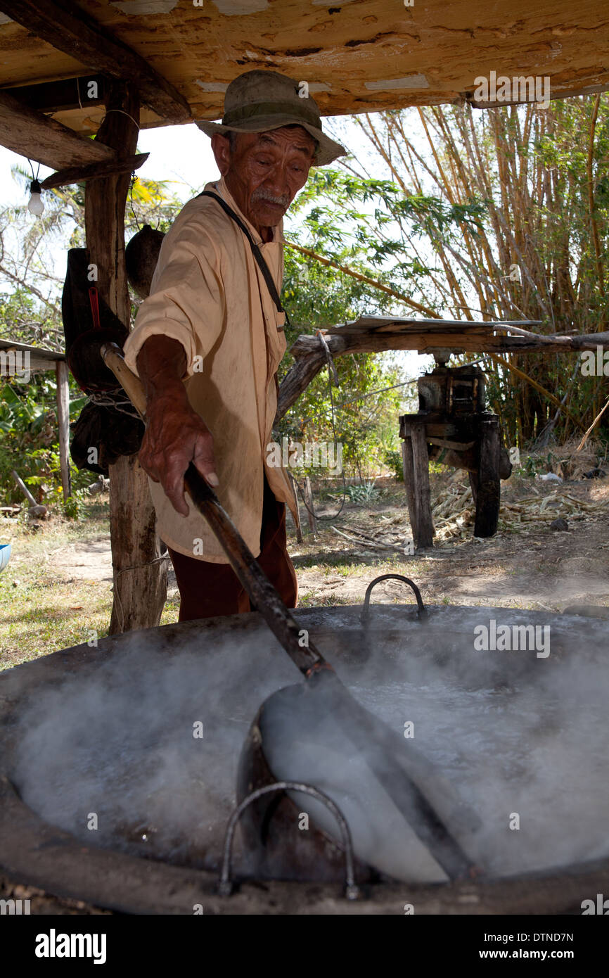 Panamaischer Bauer kocht Zuckerrohrsaft auf seiner kleinen Farm in El Rosario in der Nähe von Penonome in der Provinz Cocle, Republik Panama, Mittelamerika. Stockfoto