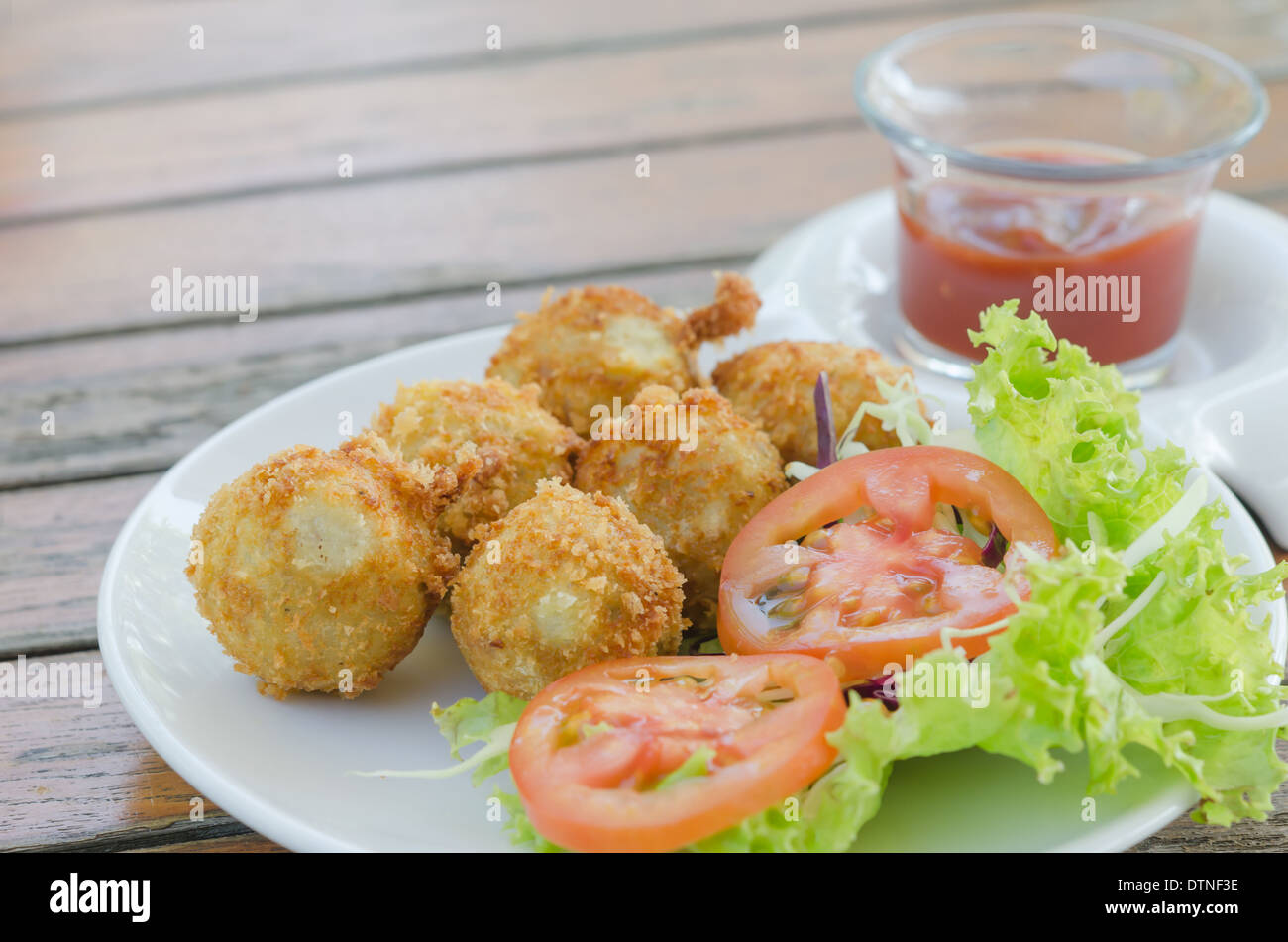 Deep Fried Kartoffelkroketten serviert mit Tomatensauce und frischem Gemüse Stockfoto