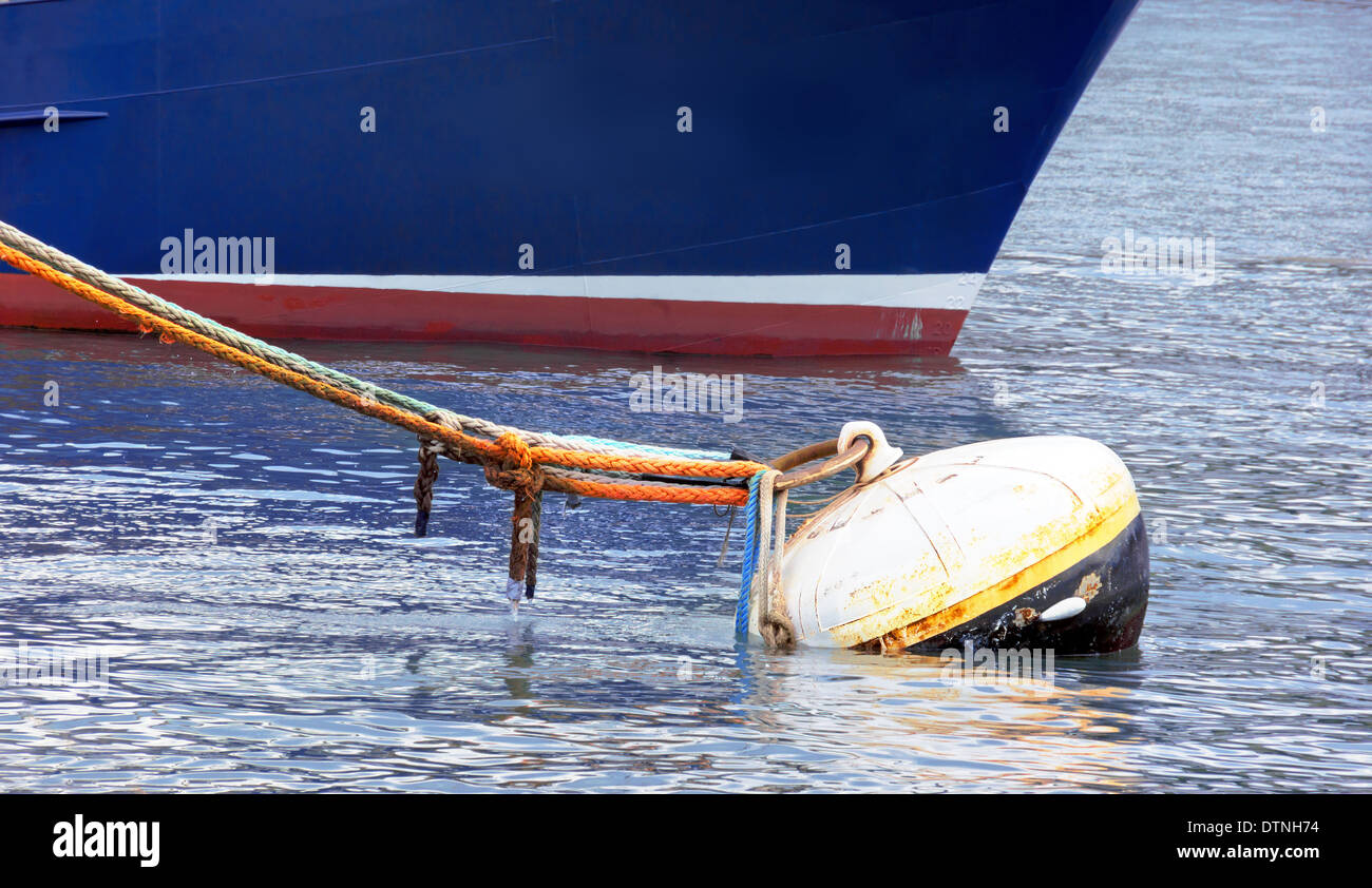 rostige Boje mit viel Seile und ein Schiff im Hafen Stockfoto