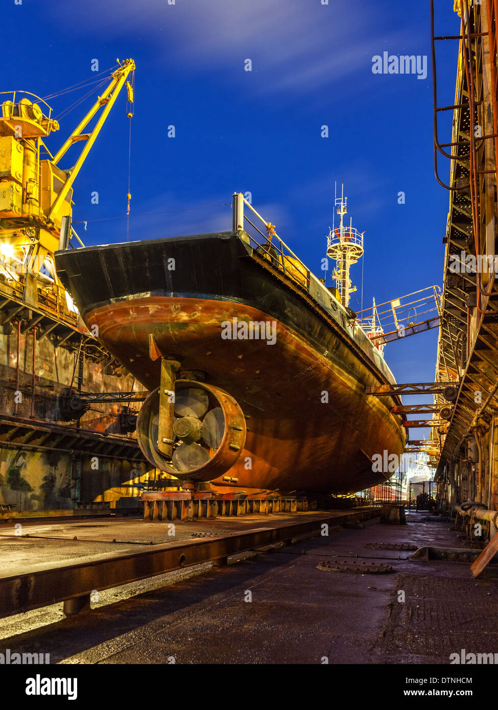 Schiffsreparatur im Trockendock in der Nacht. Stockfoto
