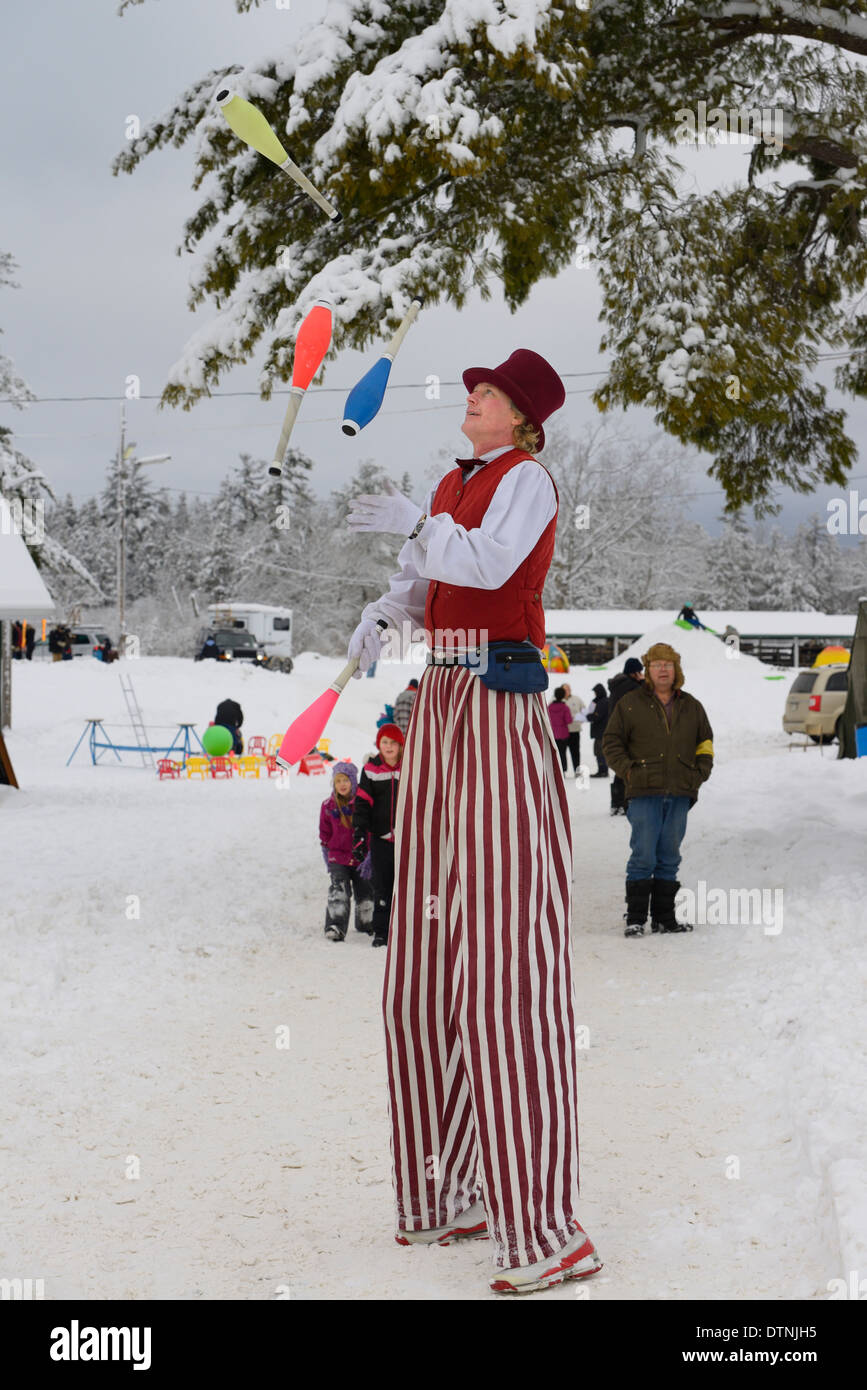 Clown Mann auf Stelzen und Hut jonglieren Pins im Winter Schnee am Mühltroff snofest 2014 Ontario Kanada Stockfoto