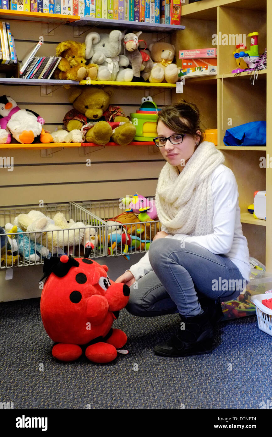 junge Frau in ein Charity-Shop betrachten Stofftier Stockfoto