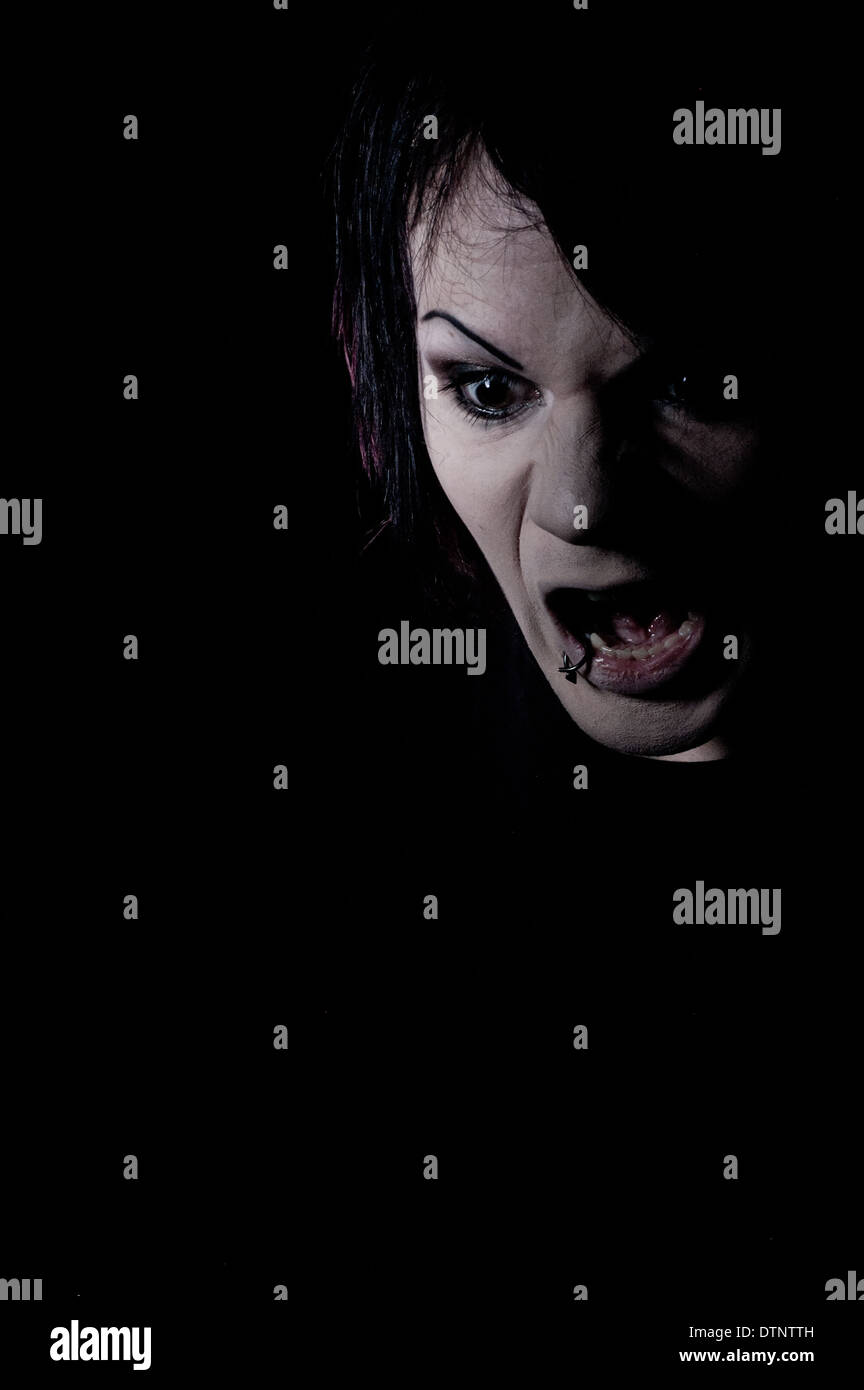 Zorniger Mann, schreien, schreien, eine dunkle beängstigend Kopfschuss, stimmungsvolle Porträt genommen vor schwarzem Hintergrund Stockfoto