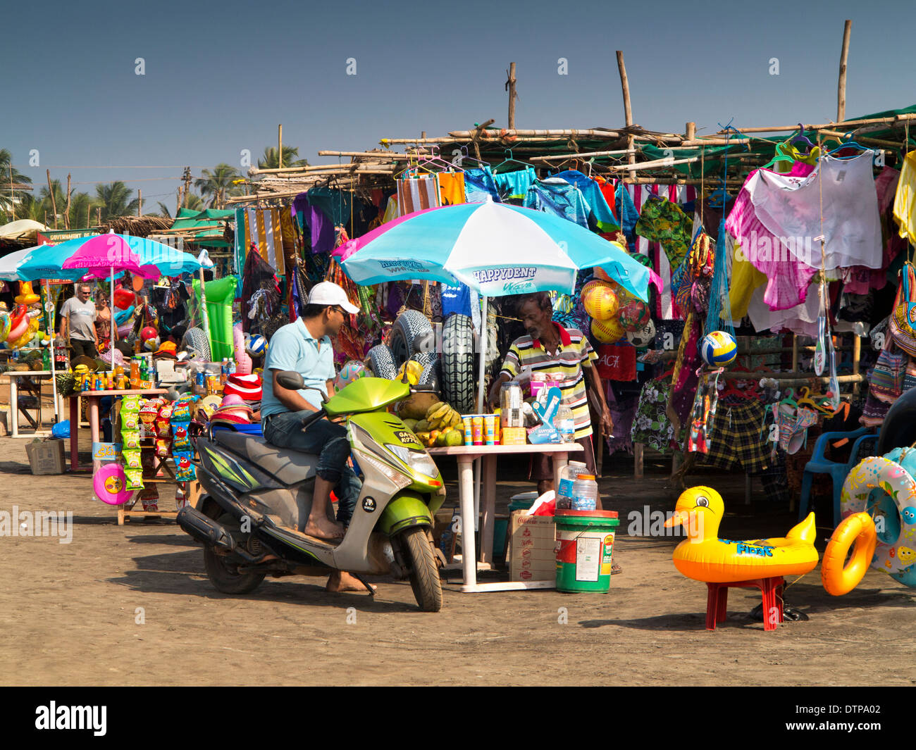 Indien, Goa, Morjim Beach, Mann auf Roller am Meer-Souvenir-shop Stockfoto