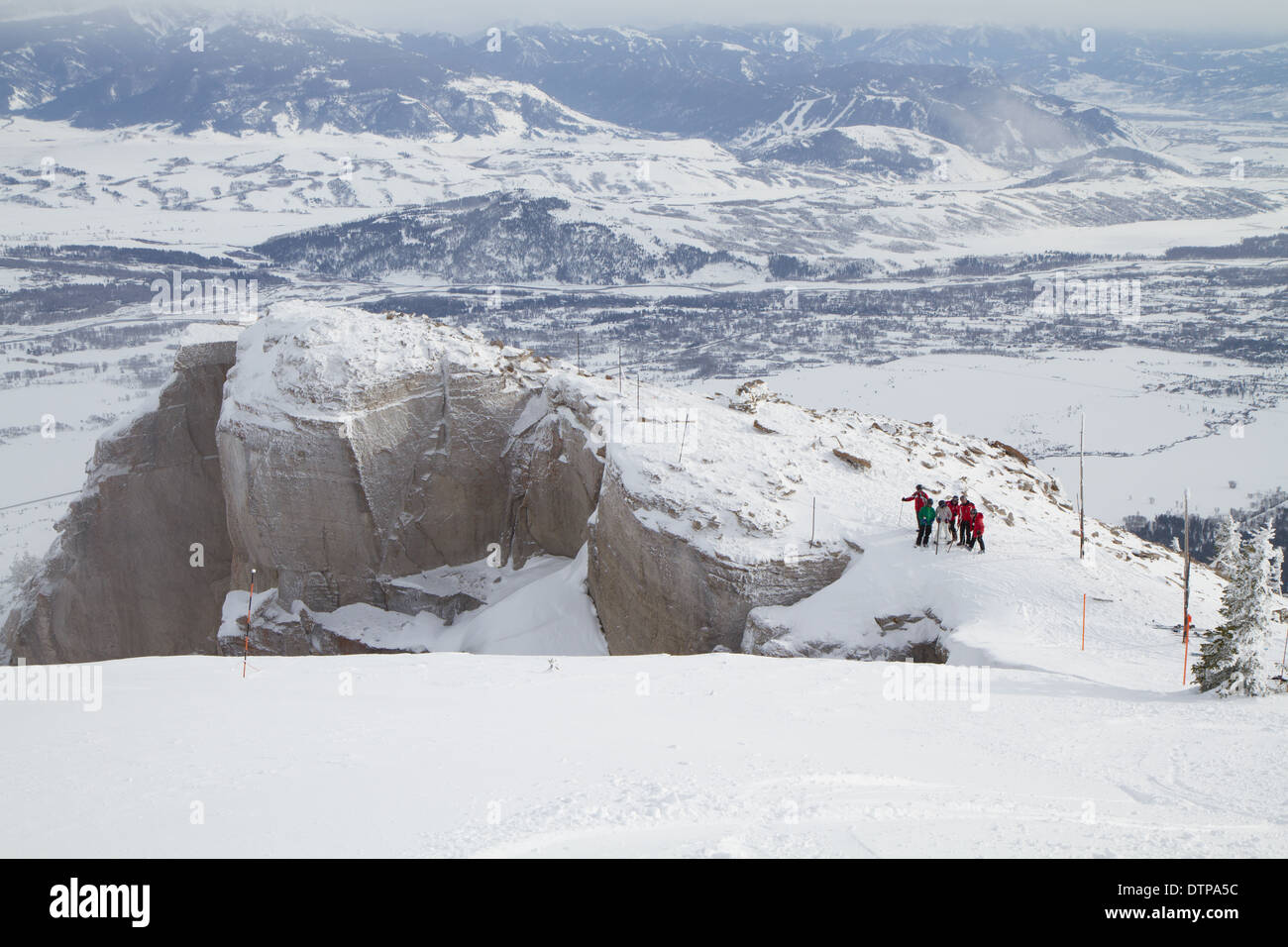 Skifahrer stehen am Rande des Corbets Coulouir, ein double Black Diamond Skirun, Jackson Hole, WY Stockfoto