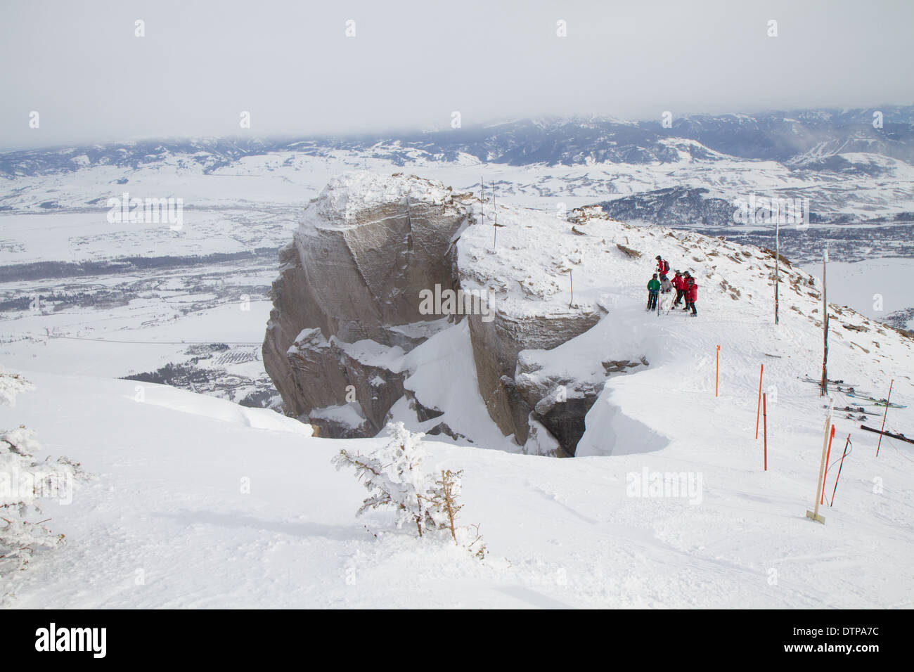 Skifahrer stehen am Rande des Corbets Coulouir, ein double Black Diamond Skirun, Jackson Hole, WY Stockfoto