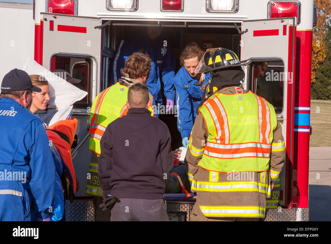EMTS laden Patienten in einen Krankenwagen Stockfoto