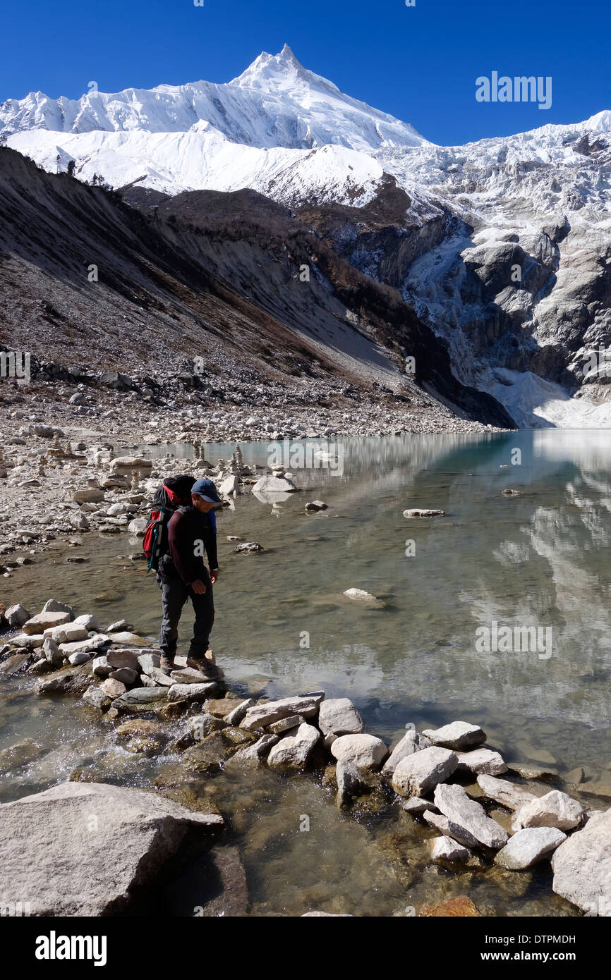 Überqueren den Auslass des Birendra Tal (See Birendra), Nepal Trekker. Manaslu Peak ist im Hintergrund. Stockfoto