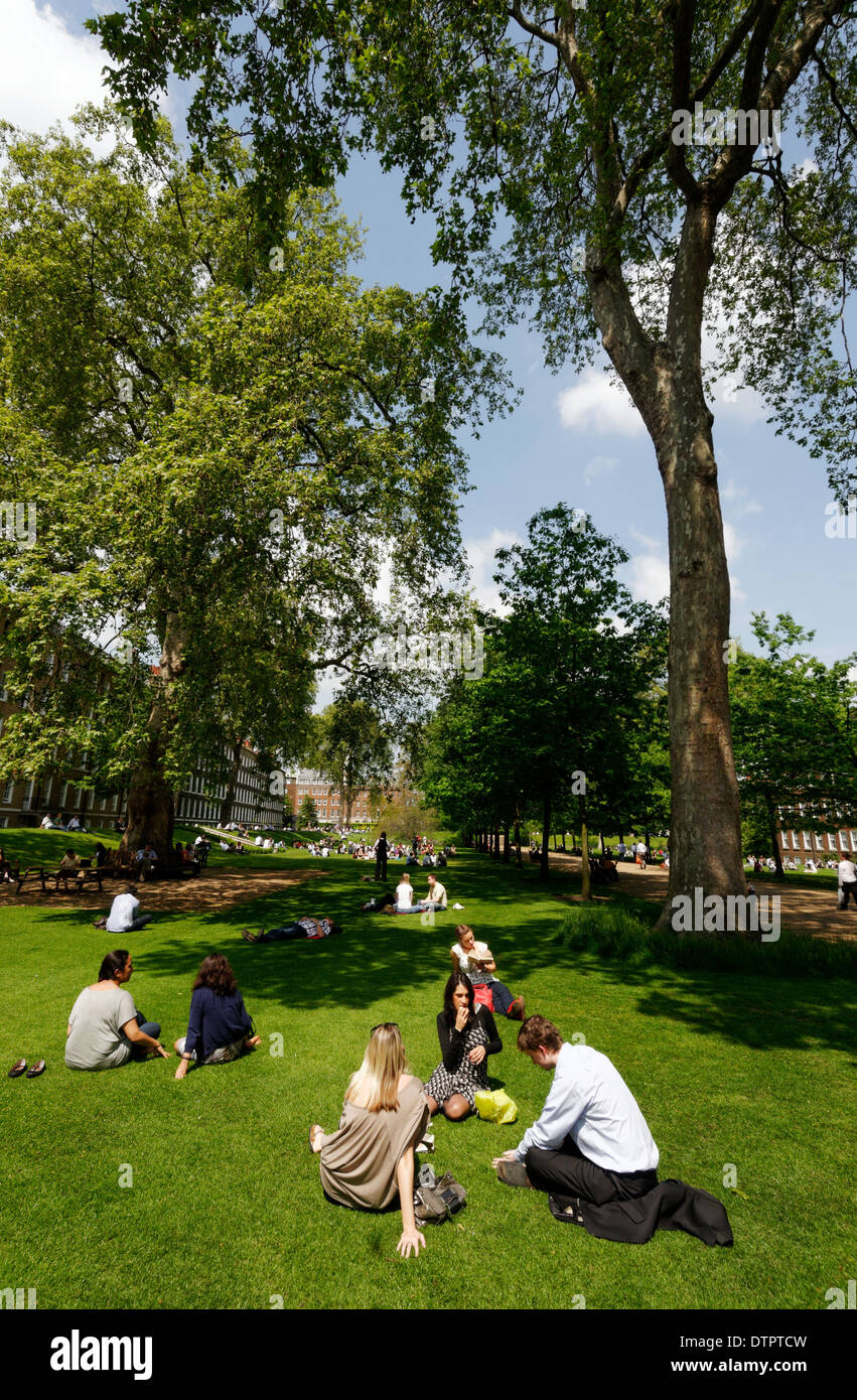 Leute sitzen in der Sonne in Grays Inn Gardens, London Stockfoto