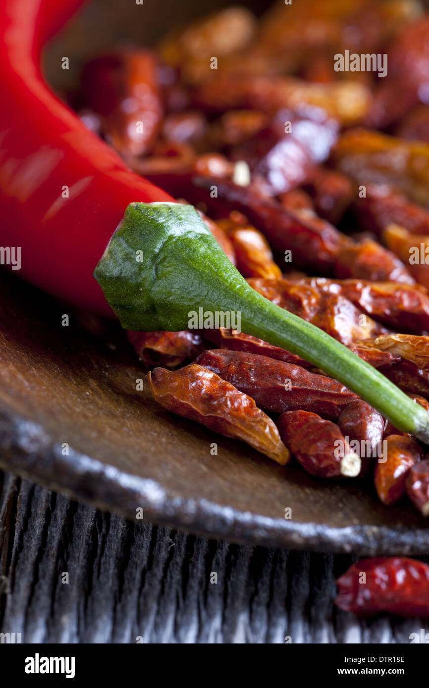 Makroaufnahme einer hot Chili Paprika auf eine hölzerne Kugel mit Getrocknete Chilischoten Stockfoto