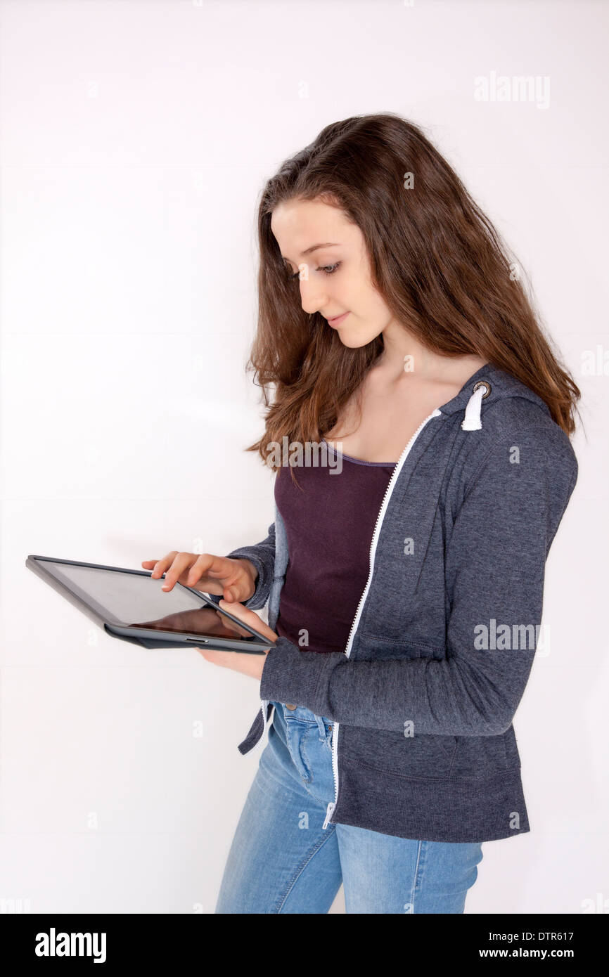 Teenager-Mädchen isoliert auf weißem Hintergrund mit einem digital-Tablette, Pensivie. Stockfoto