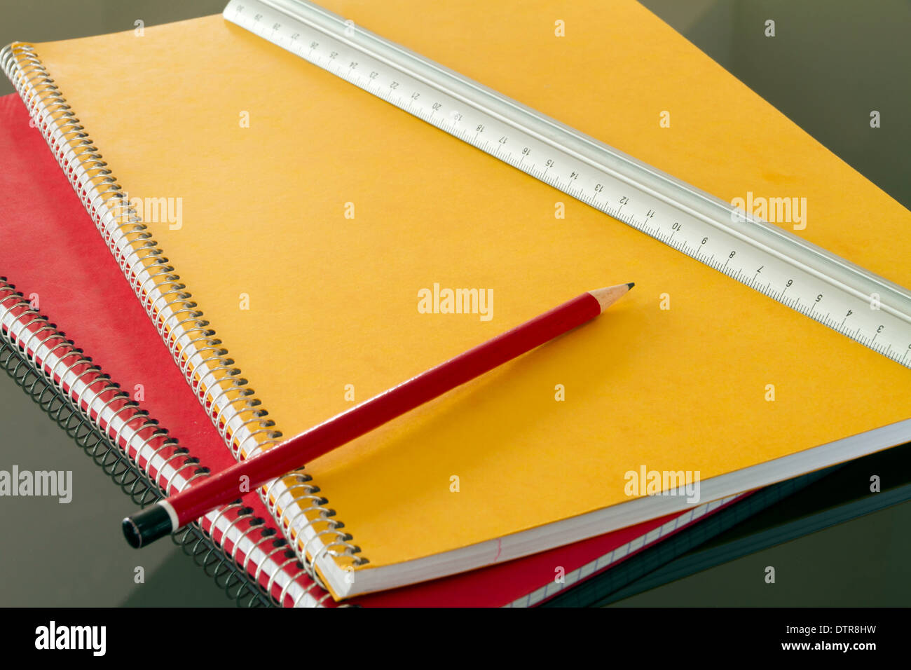 geschlossene Notizbücher mit Bleistift und Lamelle Stockfoto