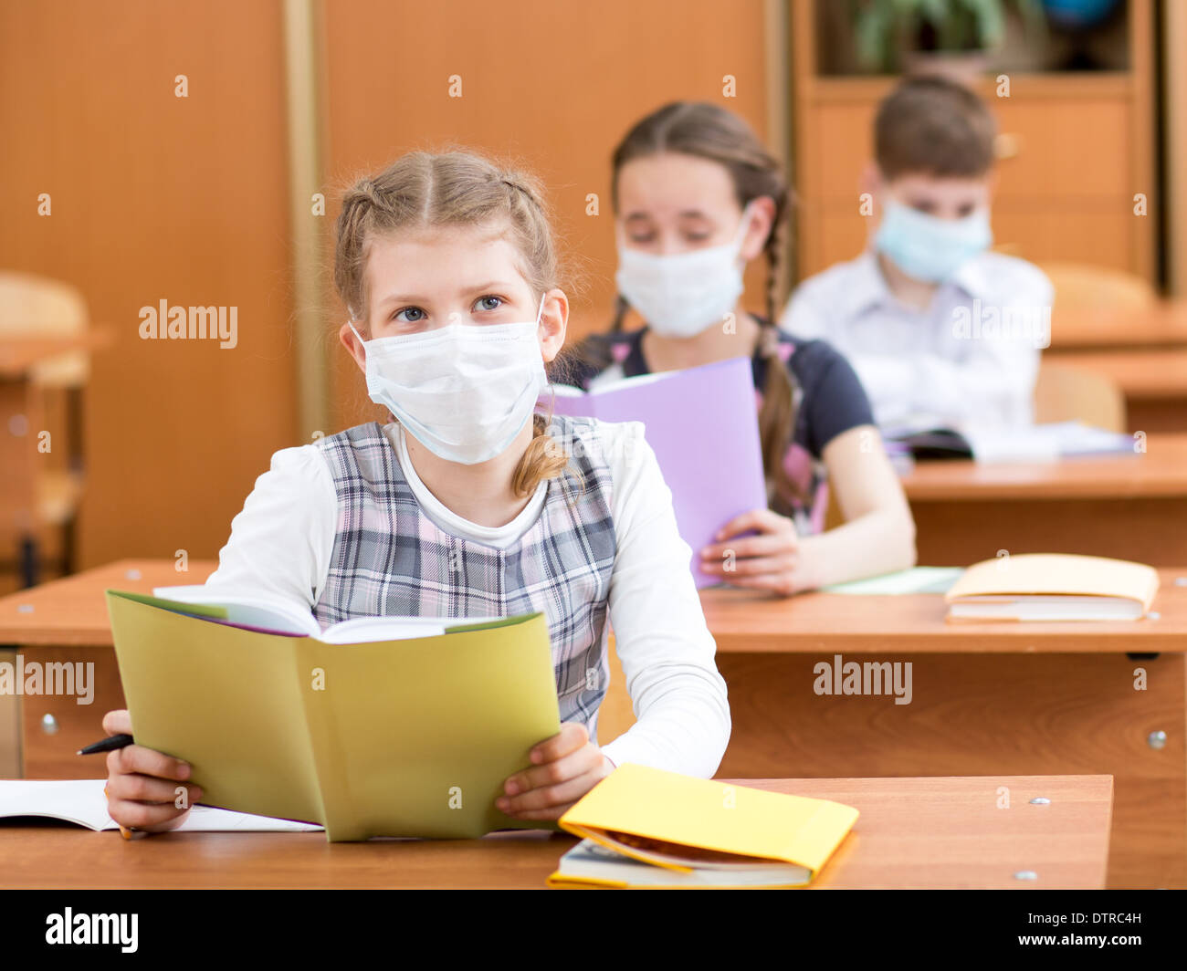 Schulkinder mit Maske Schutz gegen Grippe-Virus bei Lektion Stockfoto