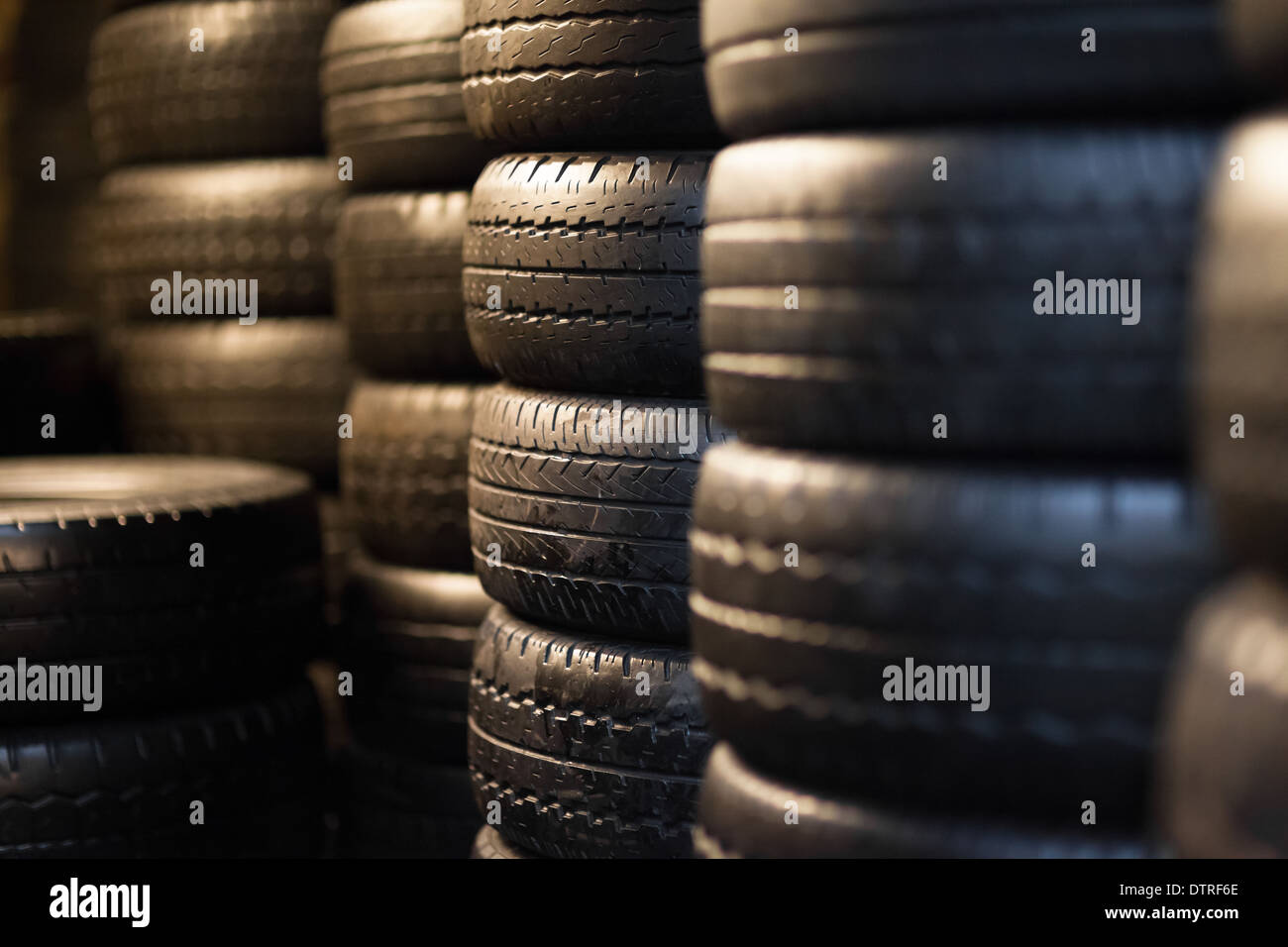 Stapel von Pkw-Reifen in einem Distributionszentrum, künstliche Beleuchtung Stockfoto