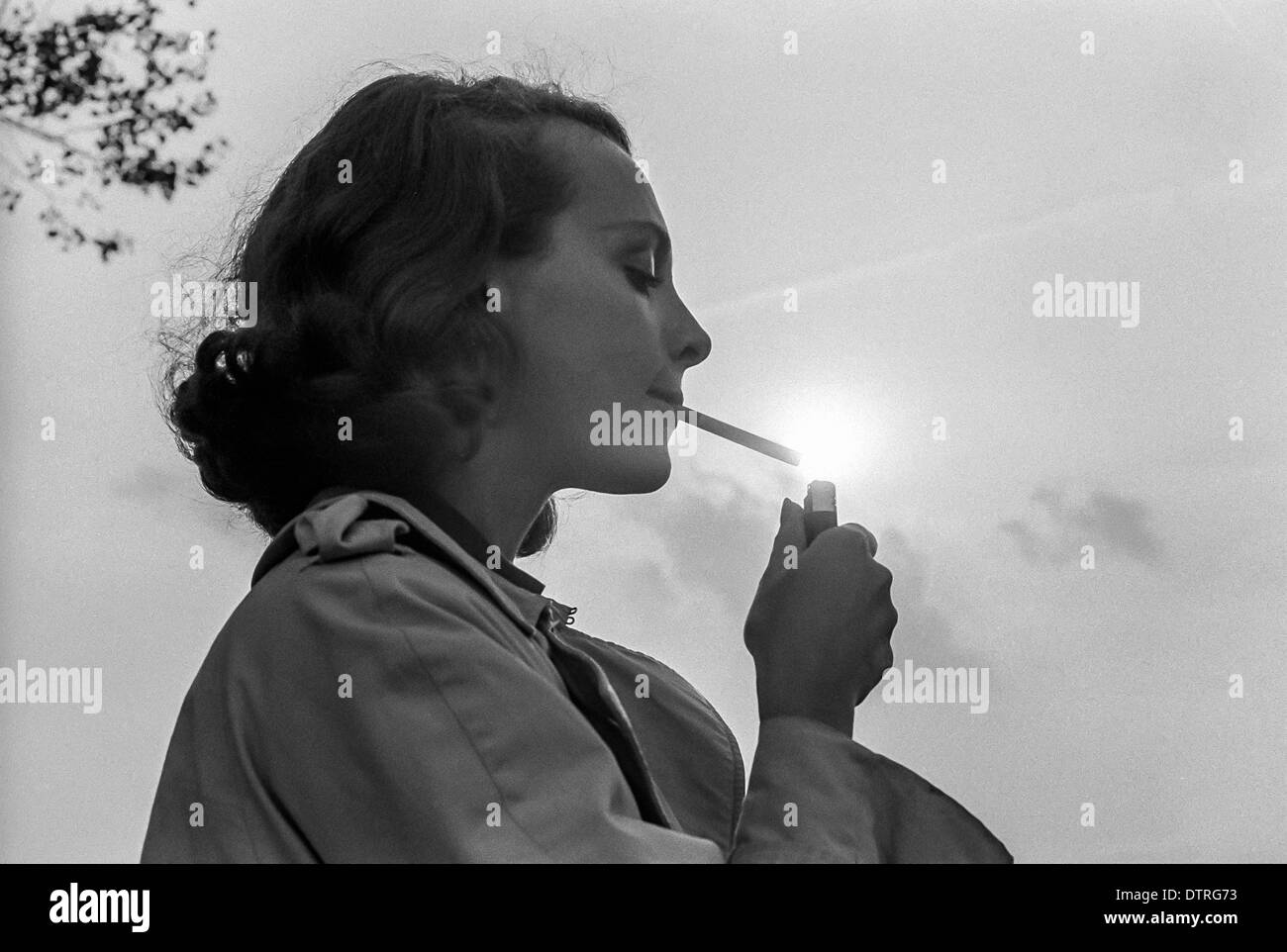 Junge Frau zündet sich eine Zigarette Stockfoto