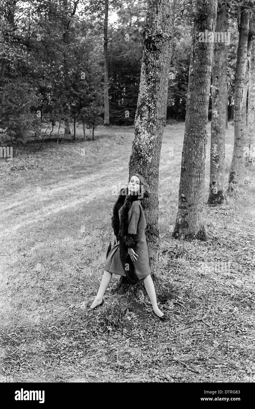 60er Jahre Mode-Modell mit Pelzmantel posiert im Wald Stockfoto