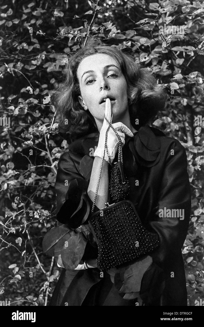 60er Jahre Mode Model Portrait mit schwarzem Mantel und Handtaschen Stockfoto