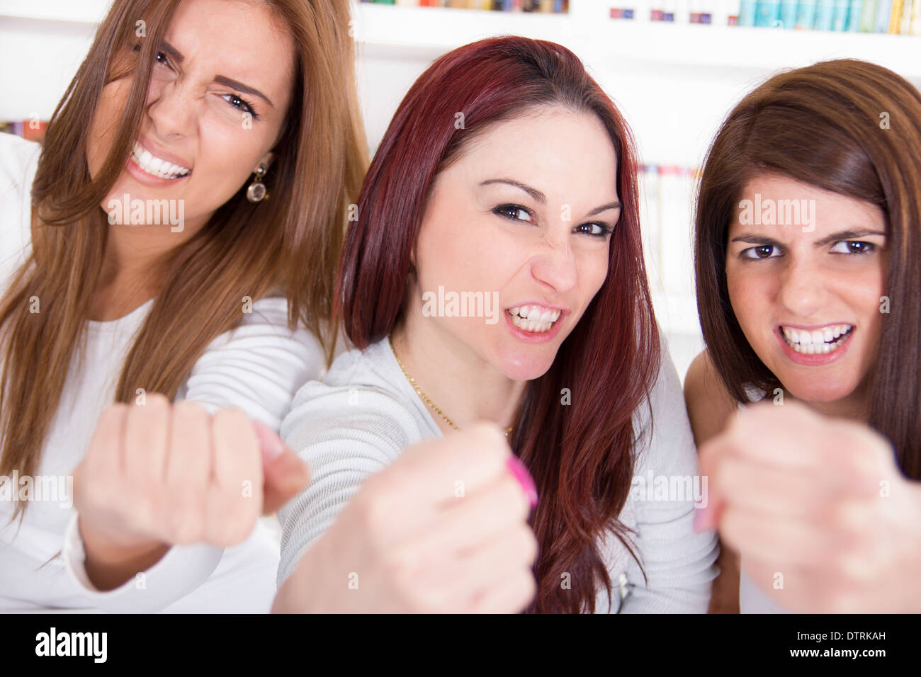 schöne Frauen halten Fäuste wie Gewinner als Zeichen für Glück, Erfolg und Sieg Stockfoto