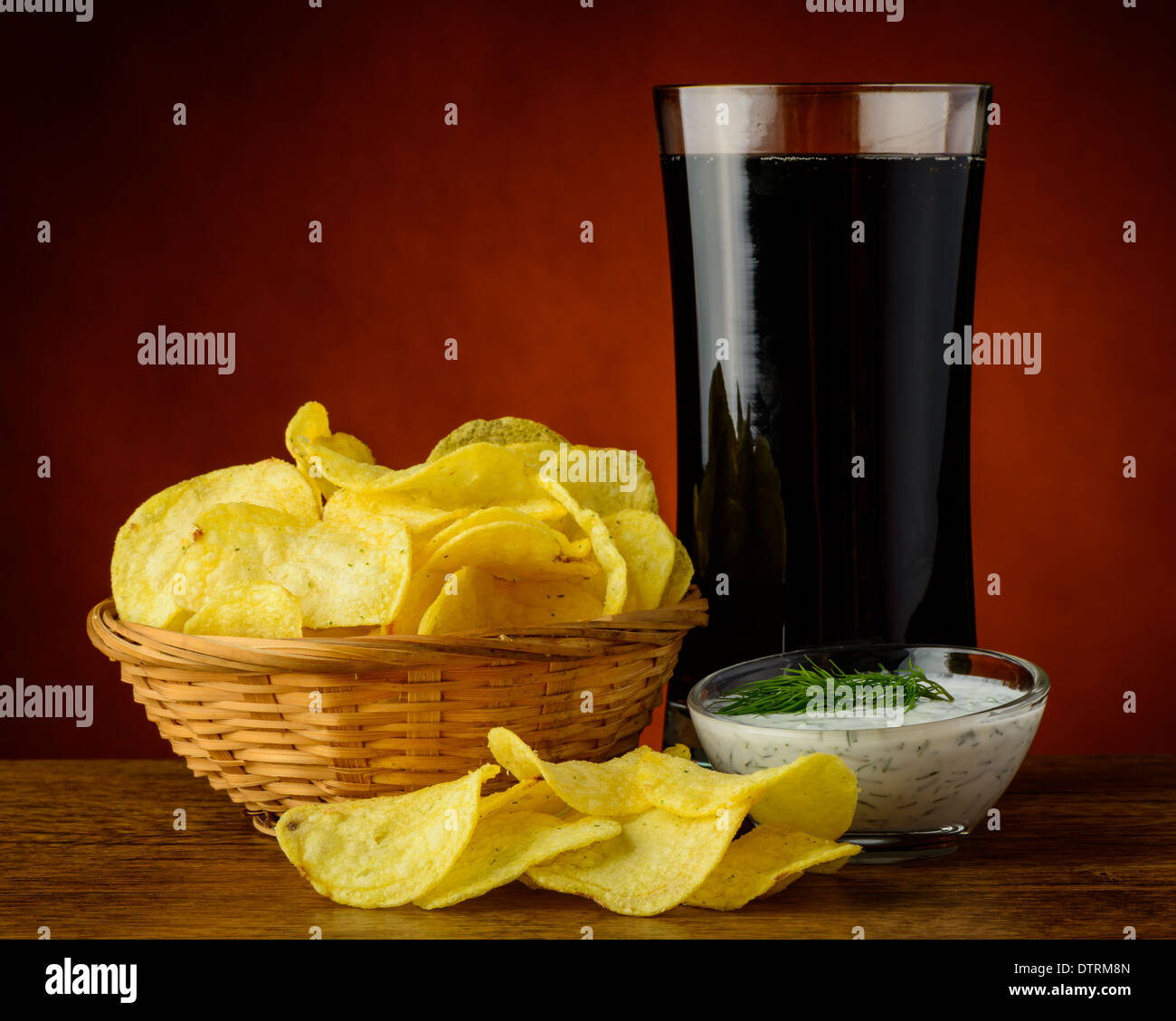 Kartoffel-Chips, Dip Dillsauce und Glas Cola trinken Stockfoto