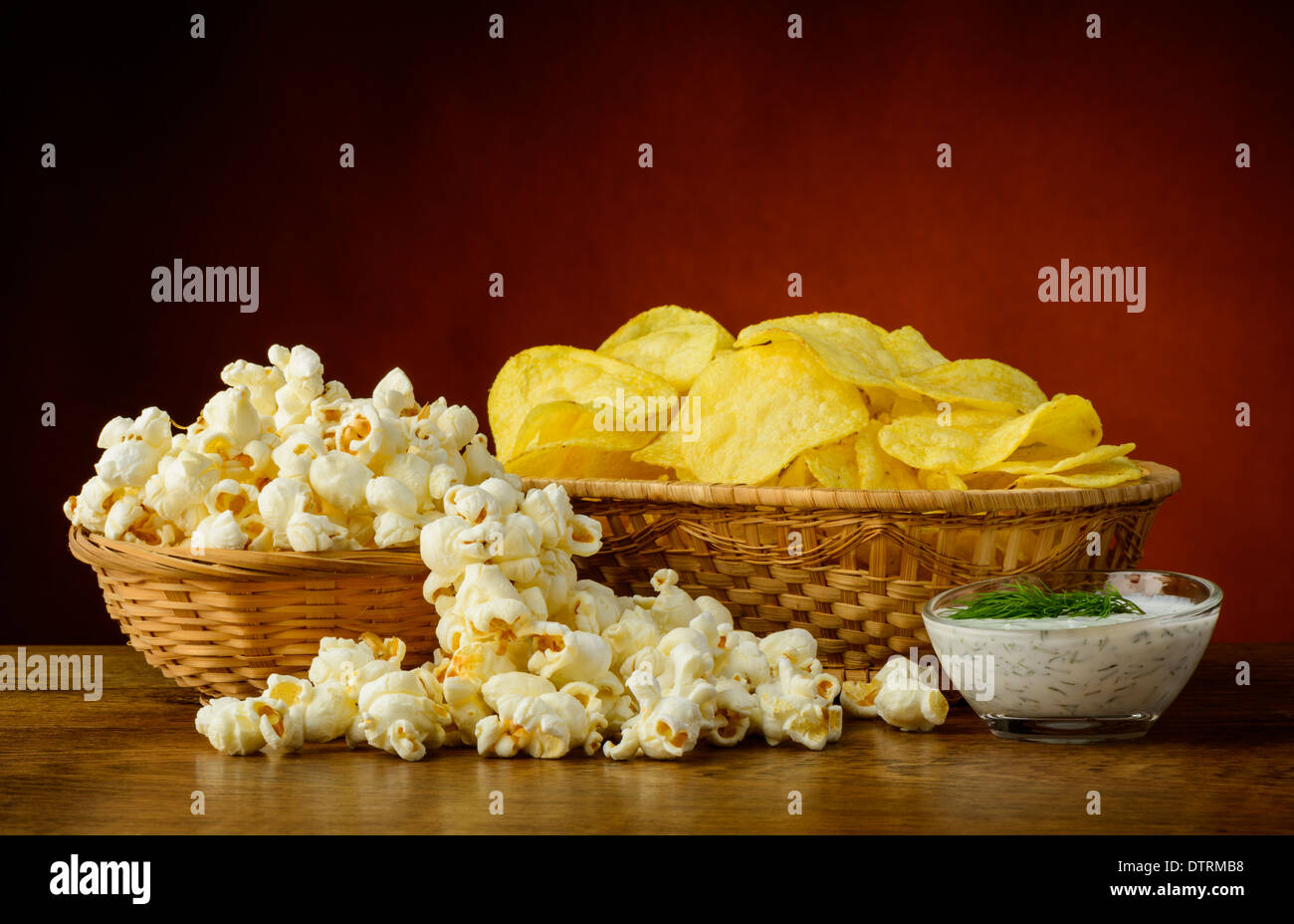 Stillleben mit Kartoffel-Chips, Popcorn und Dill dip sauce Stockfoto