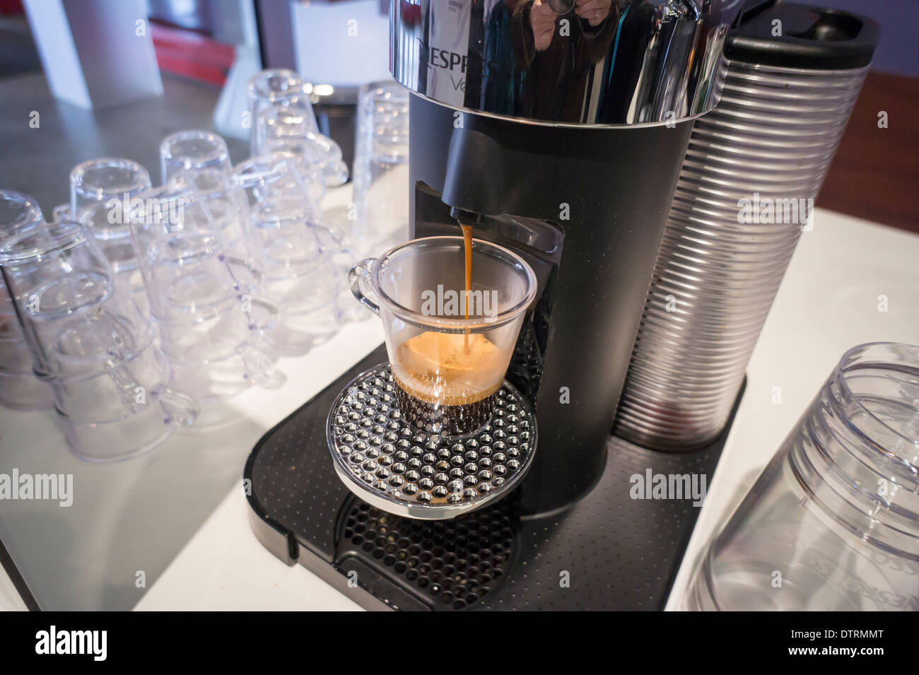 Ein Nespresso Marke einschüssigen Kaffee Brauer gießt einen Espresso an einer Werbeveranstaltung in New York Stockfoto
