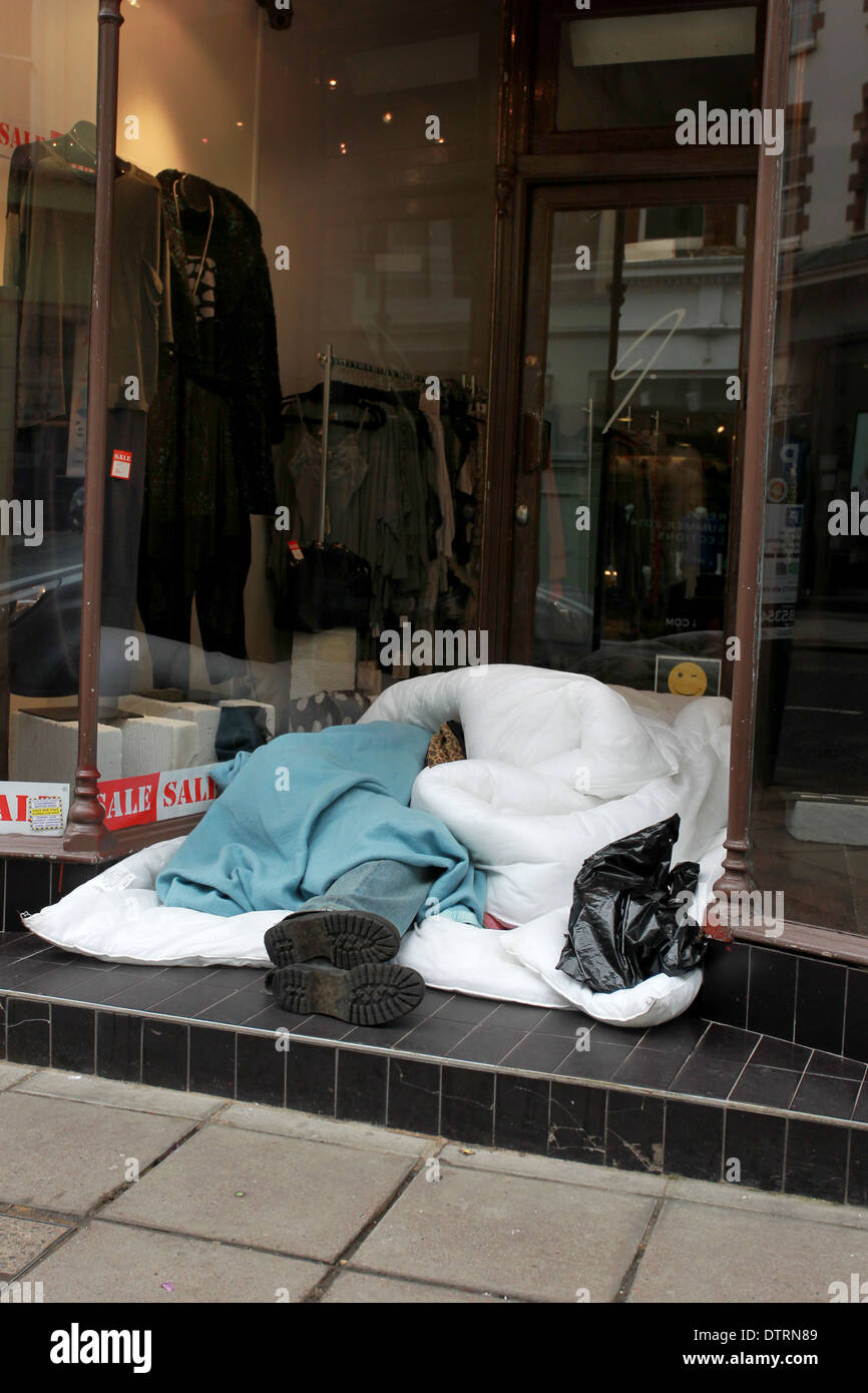 Ein Obdachloser abgebildet, schlafen in einem Kleidung Shop Eingang im Zentrum von Brighton, East Sussex, UK. Stockfoto